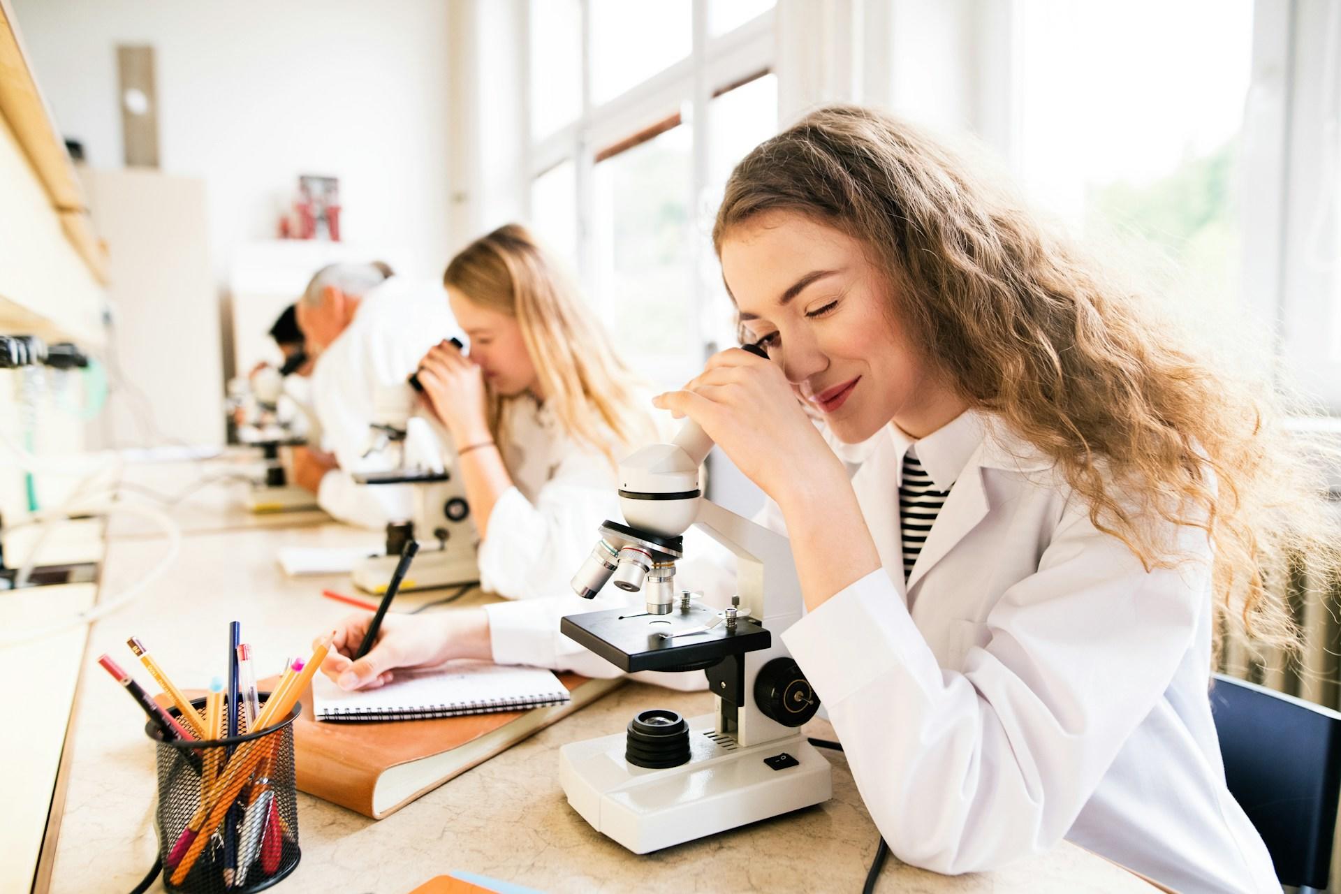 school students looking at a microscope