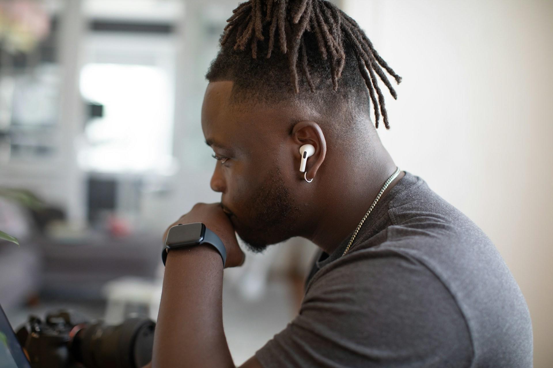 man working on a computer with earphones in