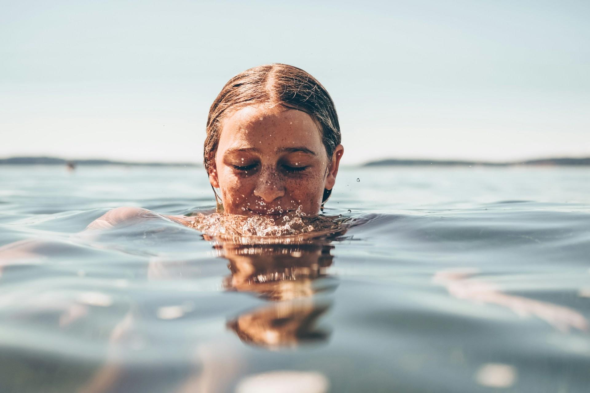 A woman swimming outdoors.
