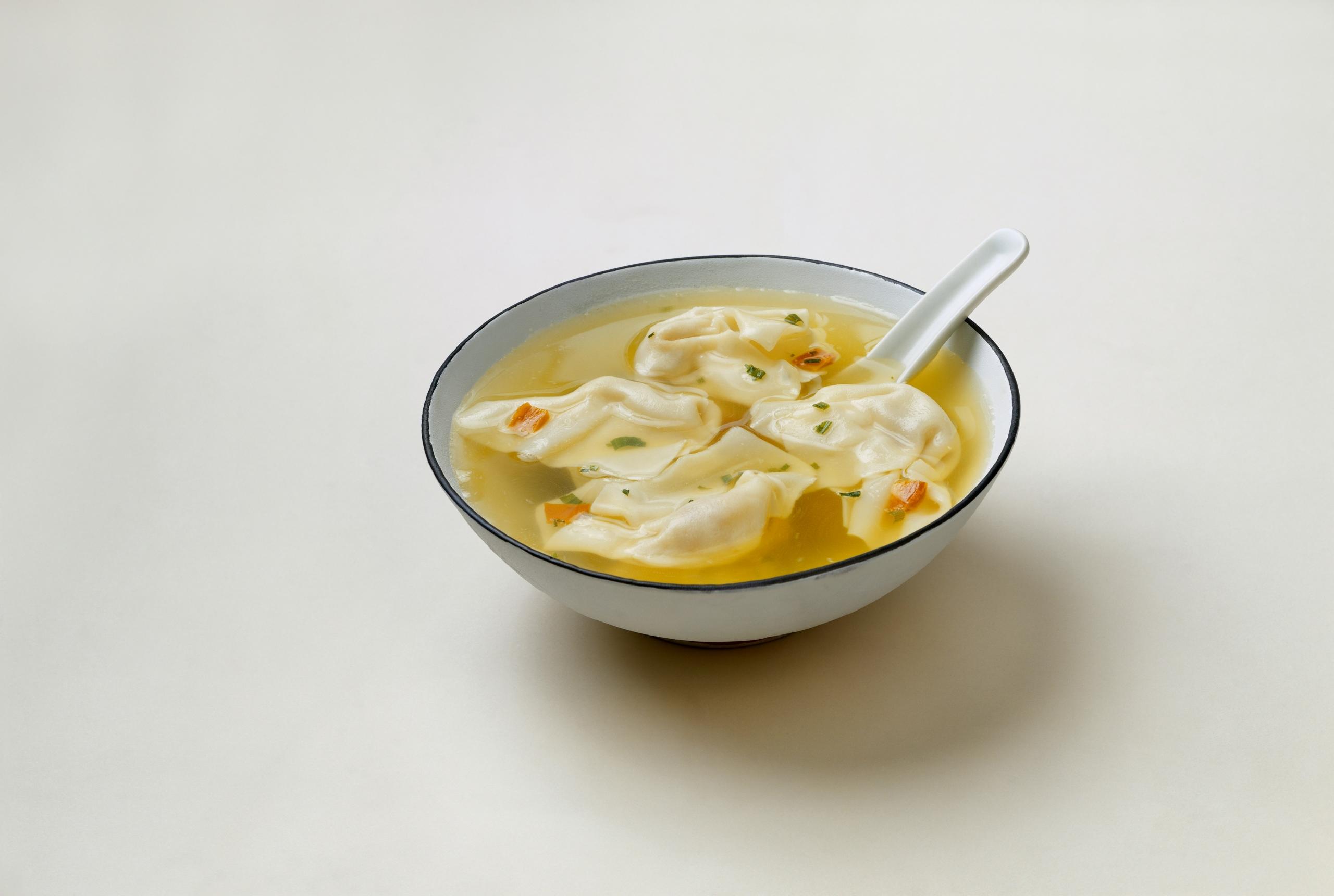 A bowl of wont soup with a white spoon.