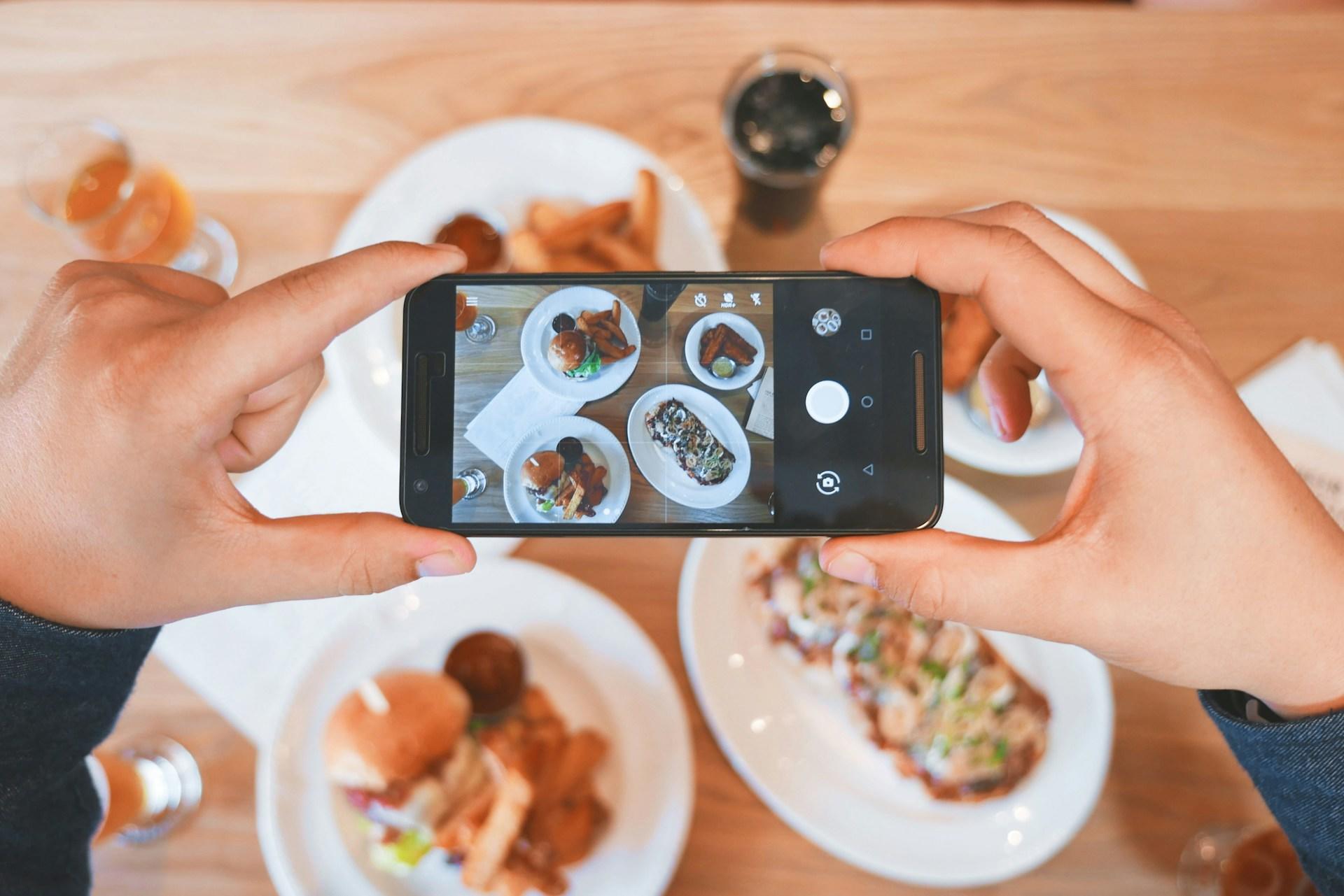 Someone taking a picture of multiple meals together to post online.