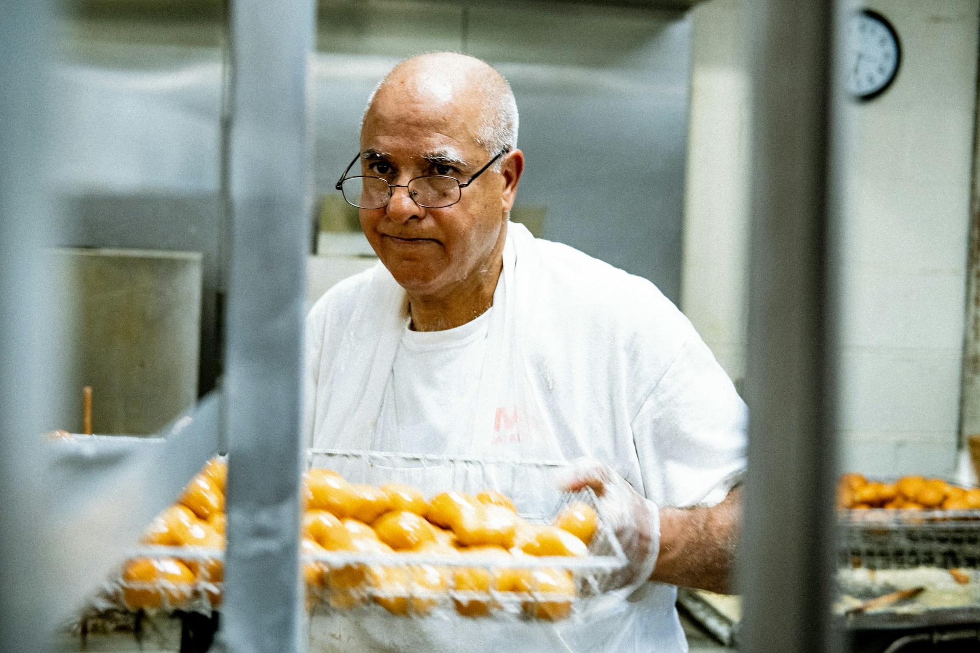 A chef holding a tray full of potatoes so he can prepare them for dinner.