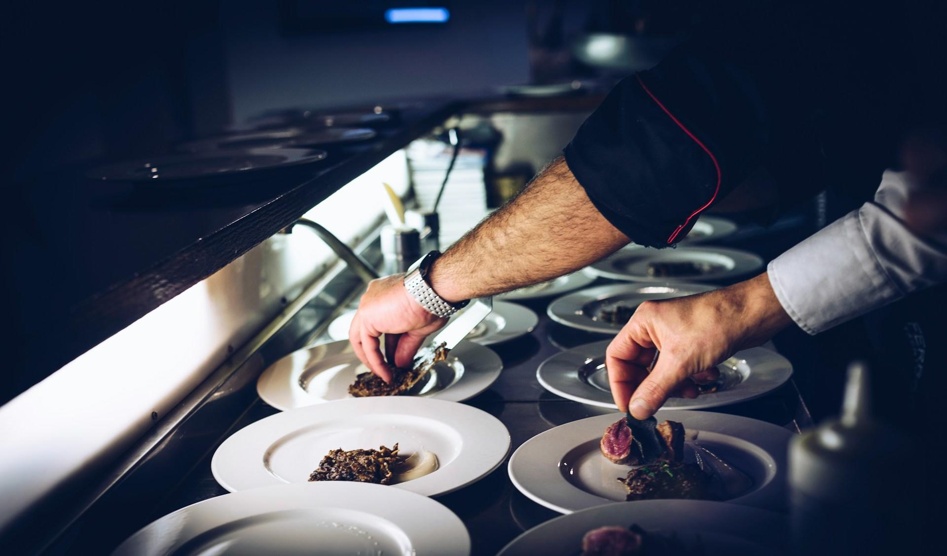A chef making the final touches while plating the dishes before they are served.