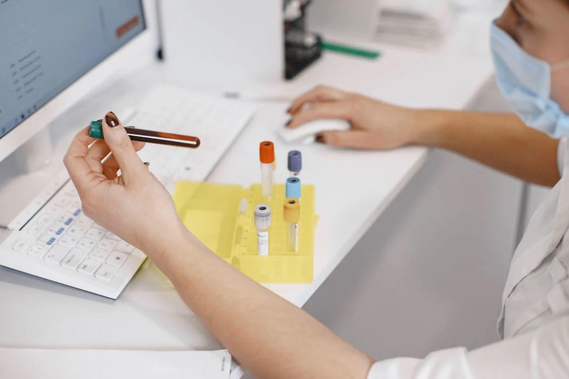 A medical student labelling test tubes in a lab.