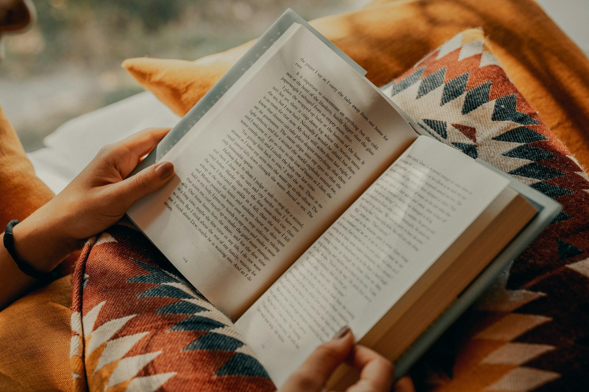 A person reading a book on their lap.