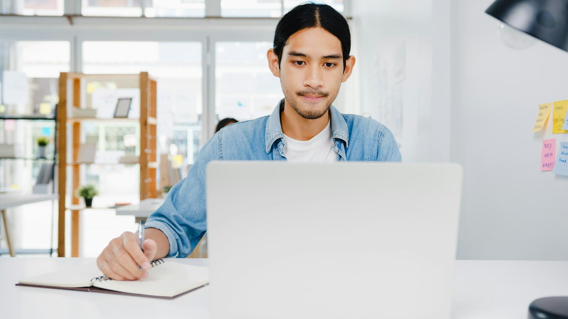 A person sits at a computer looking worried.
