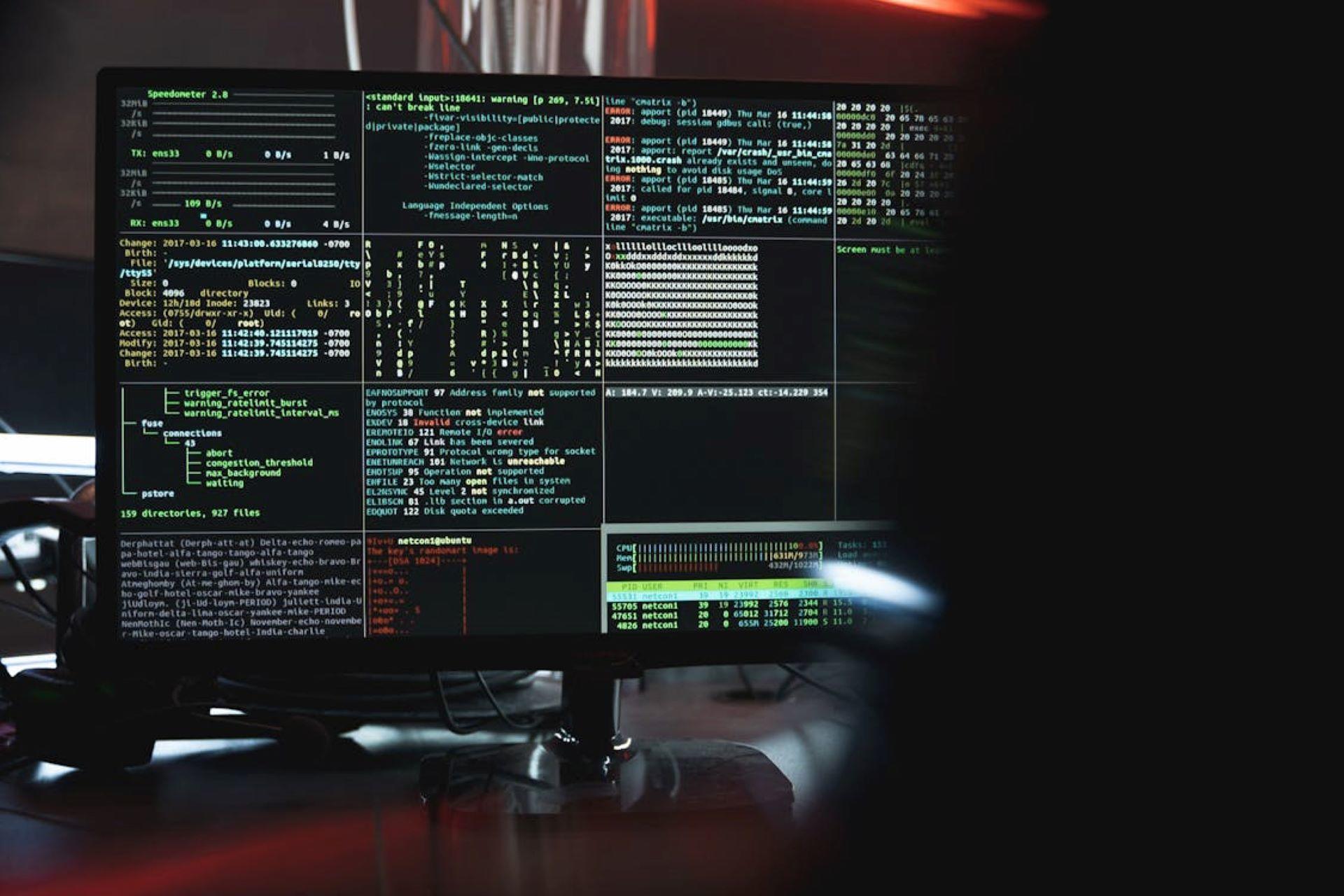 Colorful Python code displayed on a computer screen in a low-lit room.