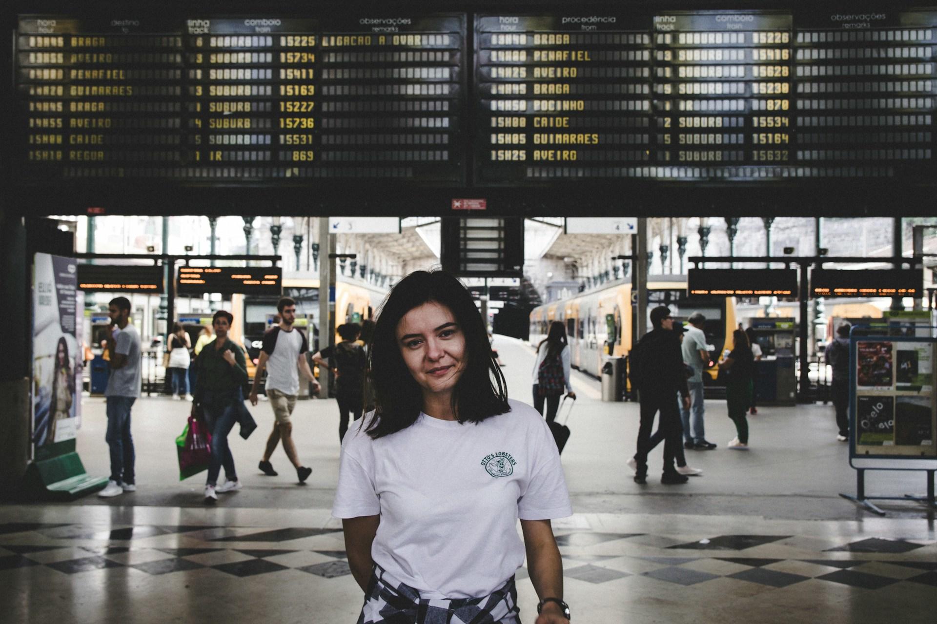 woman standing in front of a train timetable