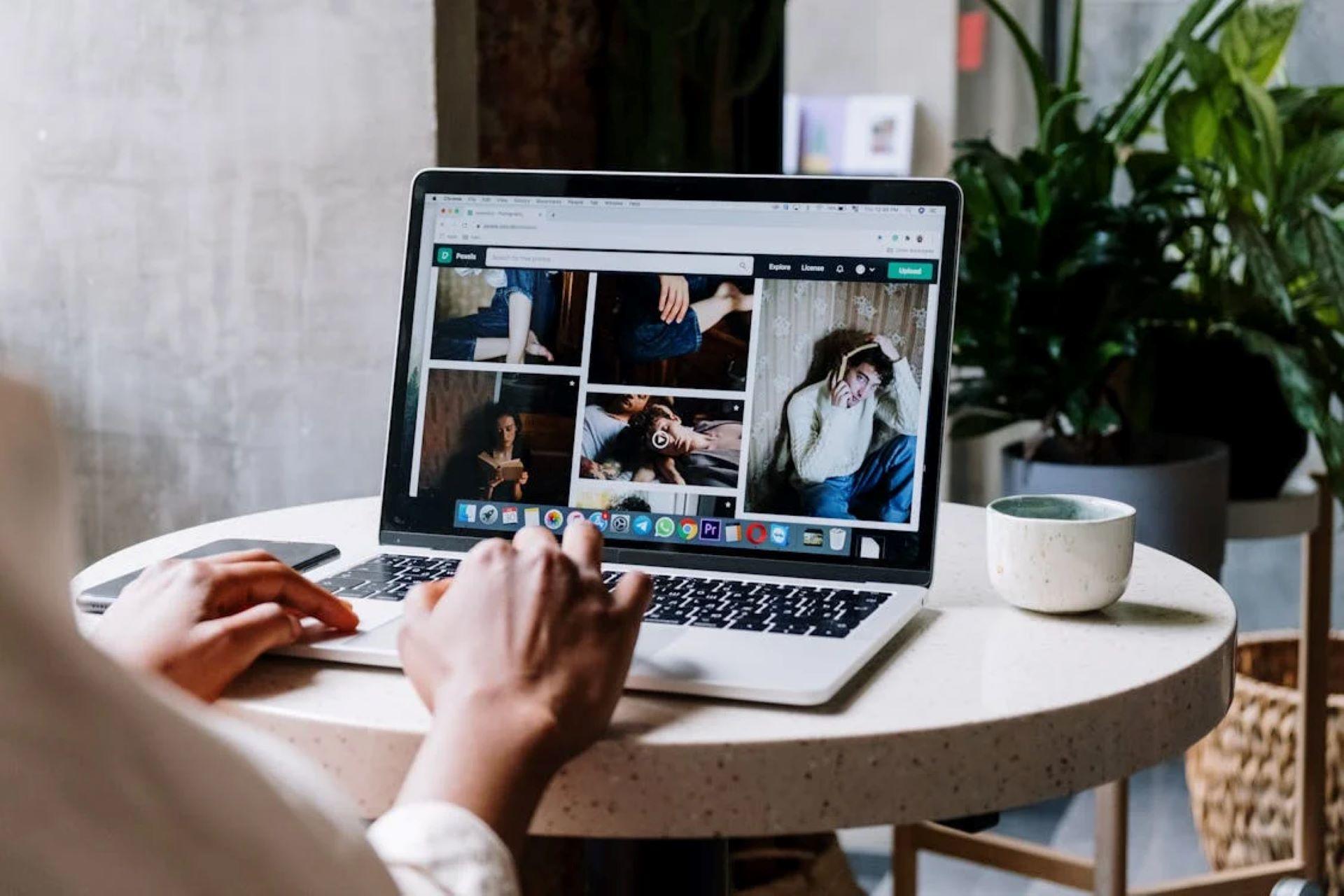 person using a laptop to view graphic design photos.