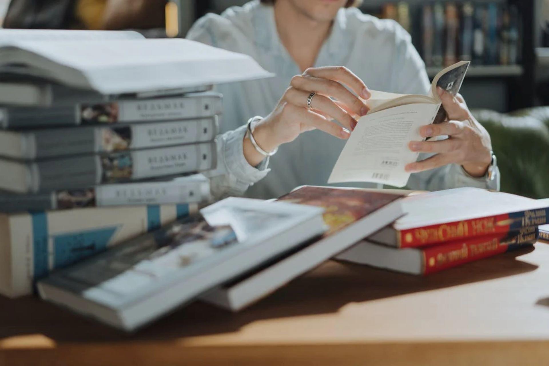 Woman reading a book on a table.