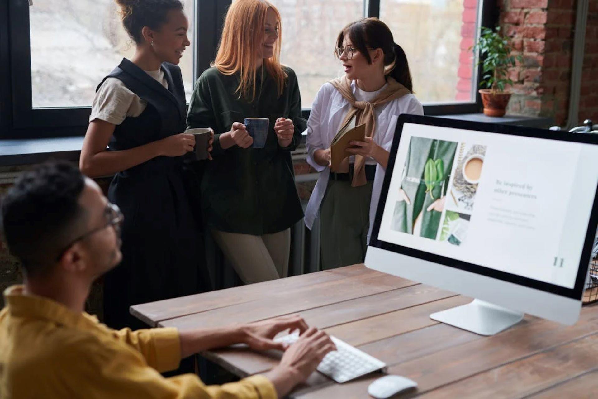 A team of four people collaborating on a project on a computer