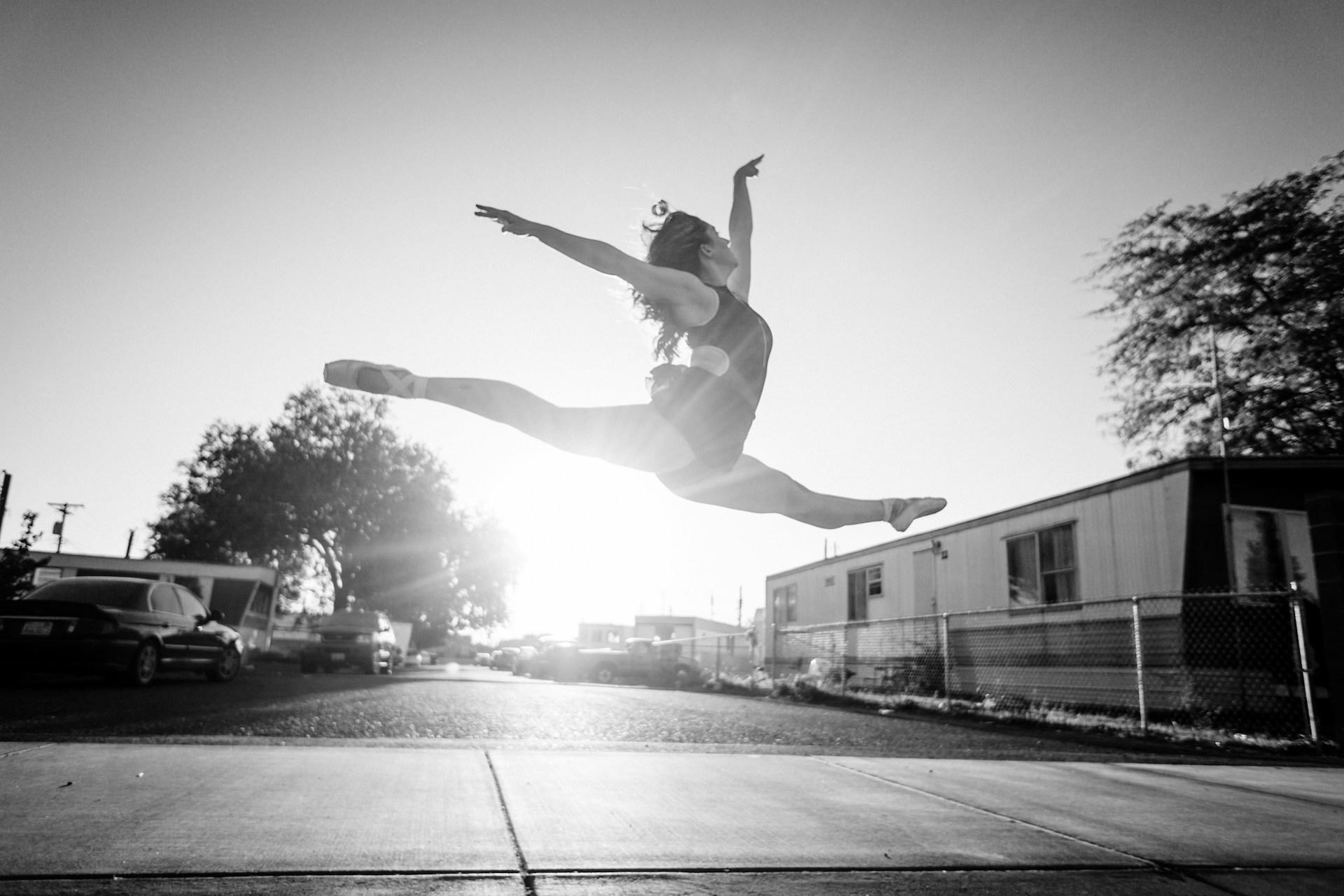 A gymnast doing the splits while jumping.
