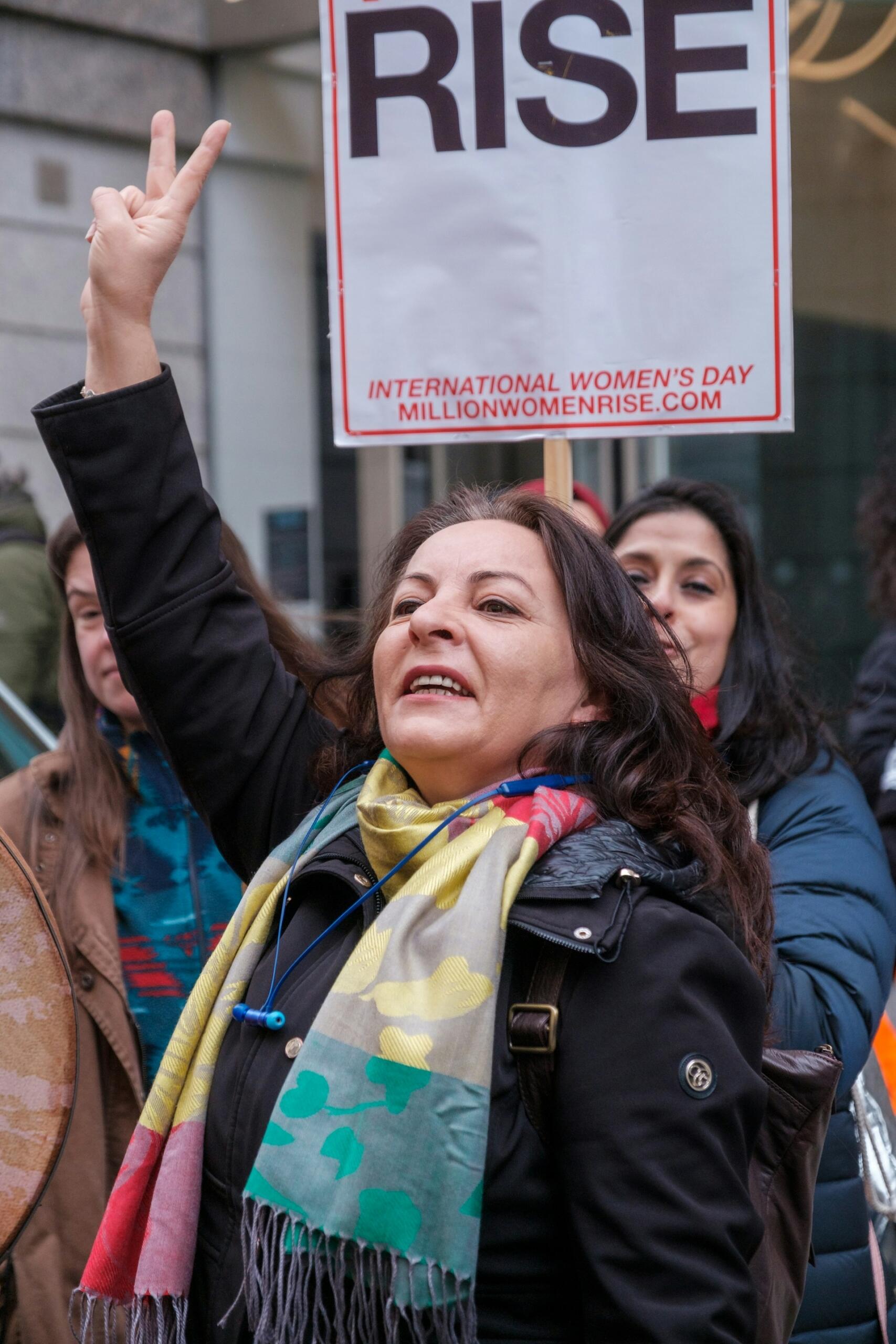 A person raises their hand at a protest. 