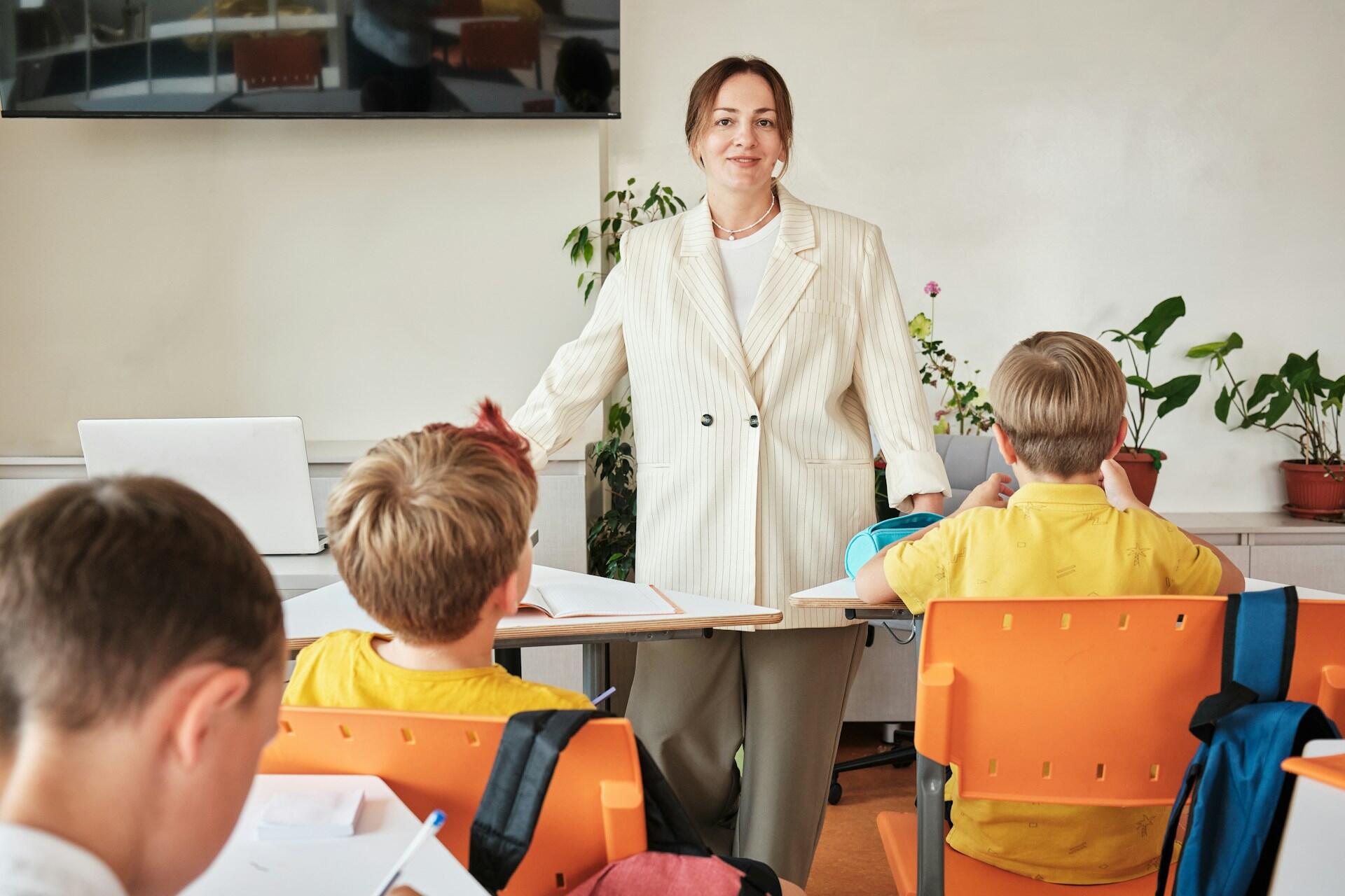 A person stands before a group of children. 