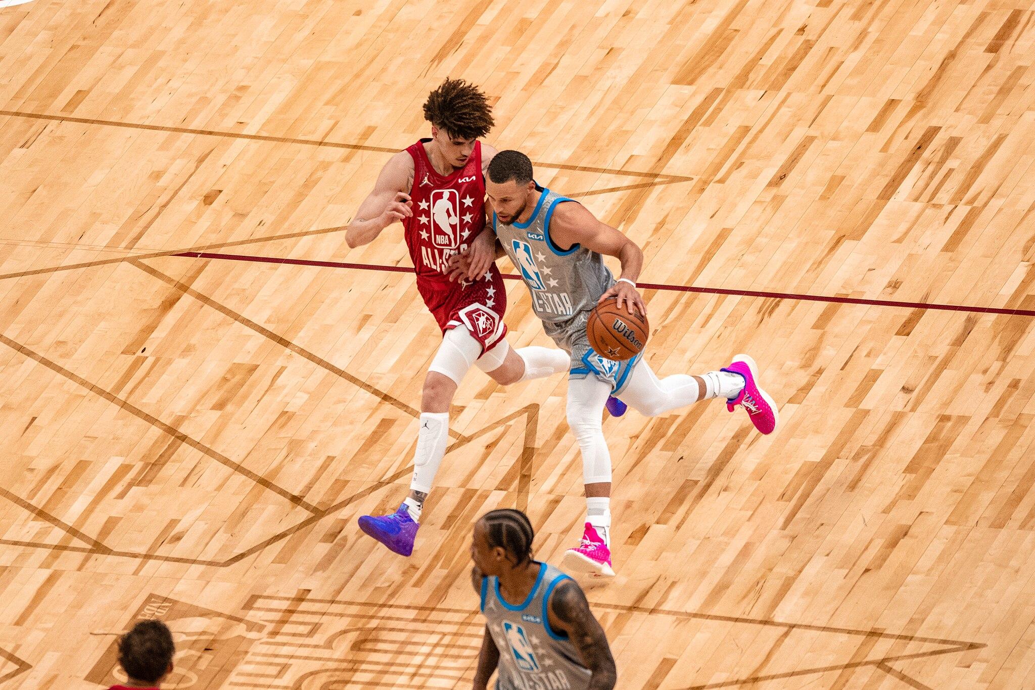 Stephen Curry diving to the basketball net.