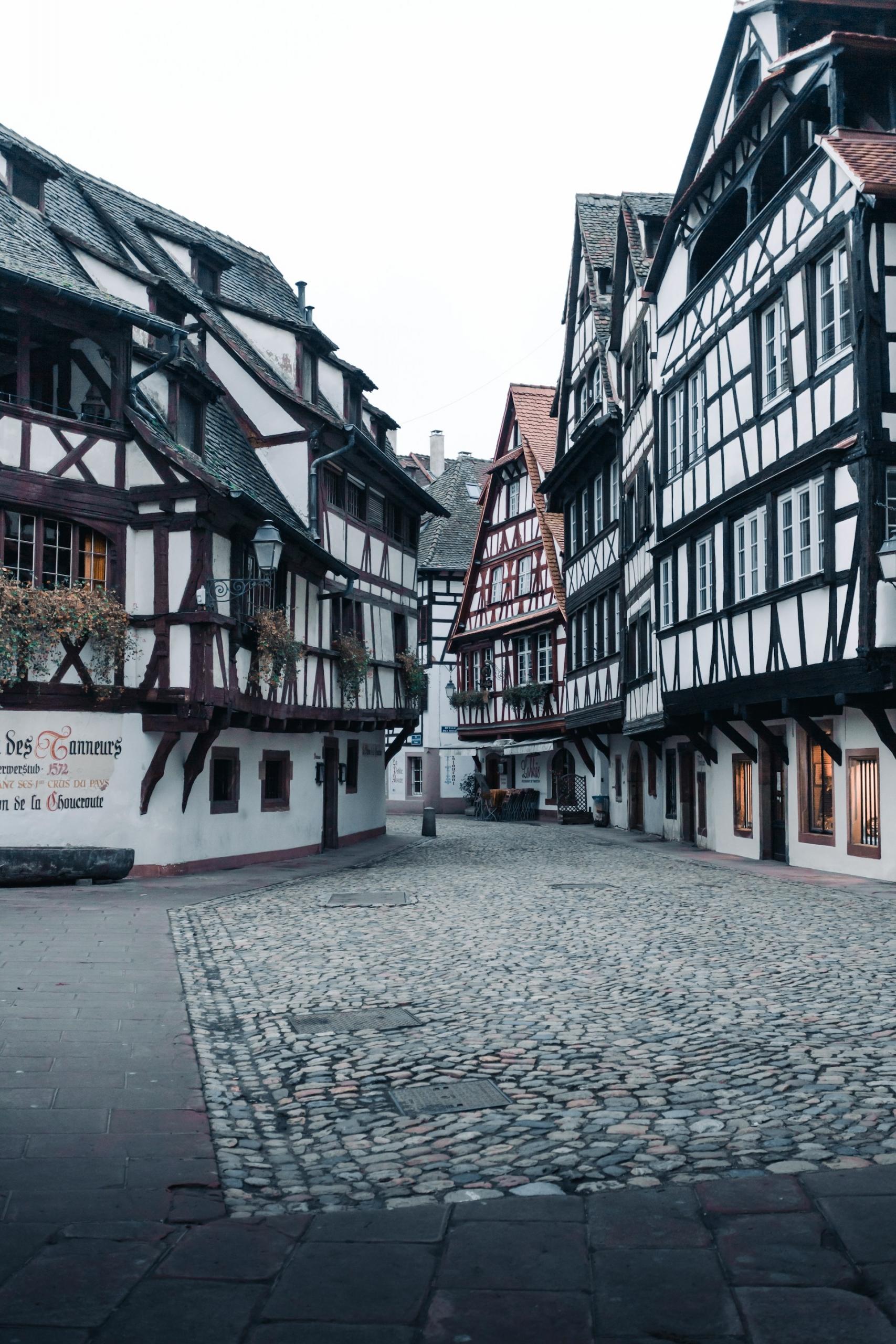 An empty cobblestoned street lined with wood-beam houses.