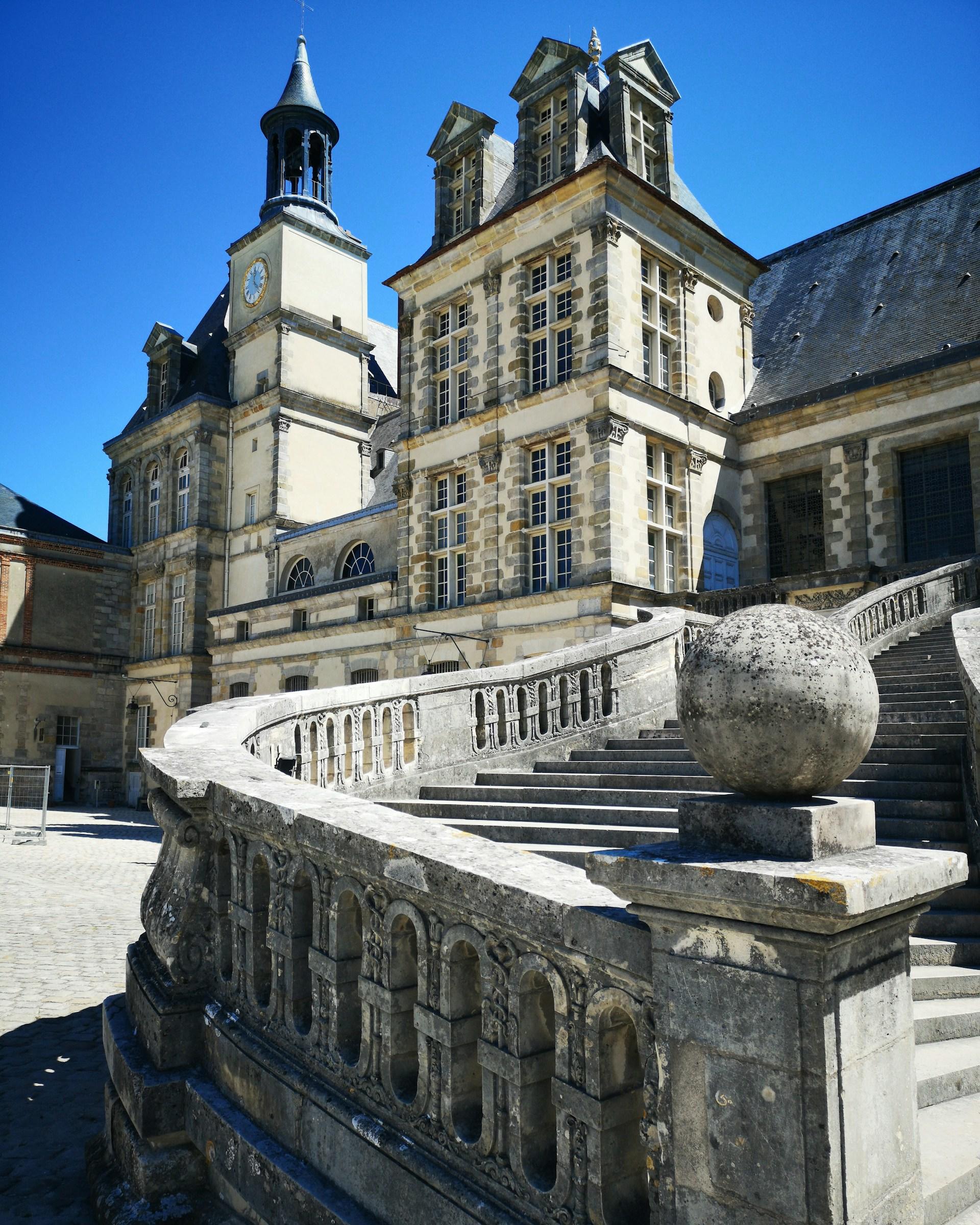 A white building with stone staircase on a sunny day.