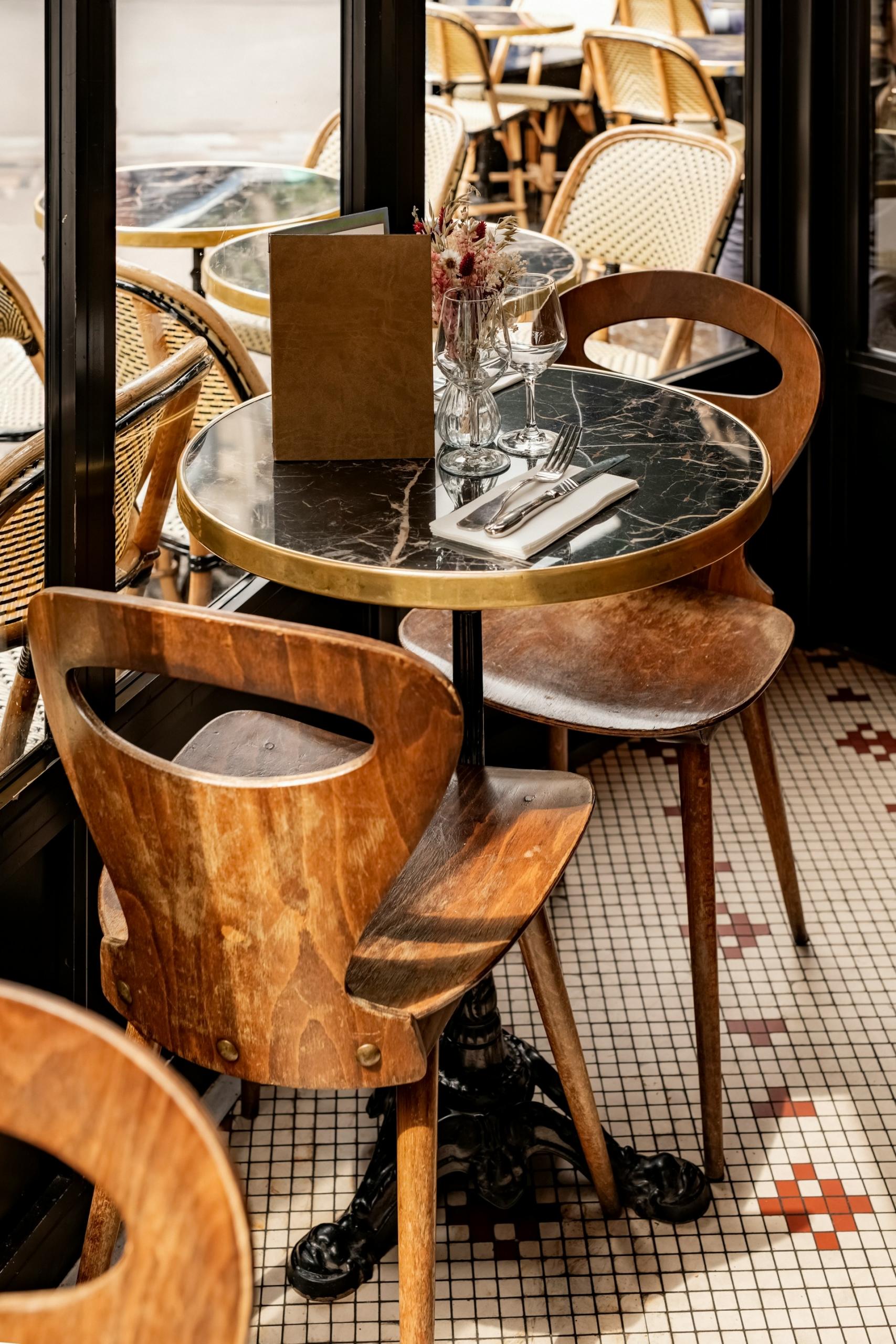 A small table with two chairs next to a window in a restaurant