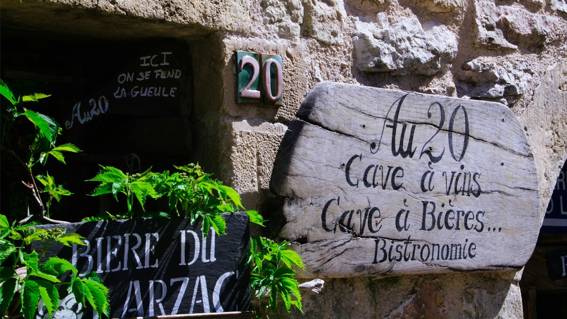 Signs in French mounted on a stone wall.