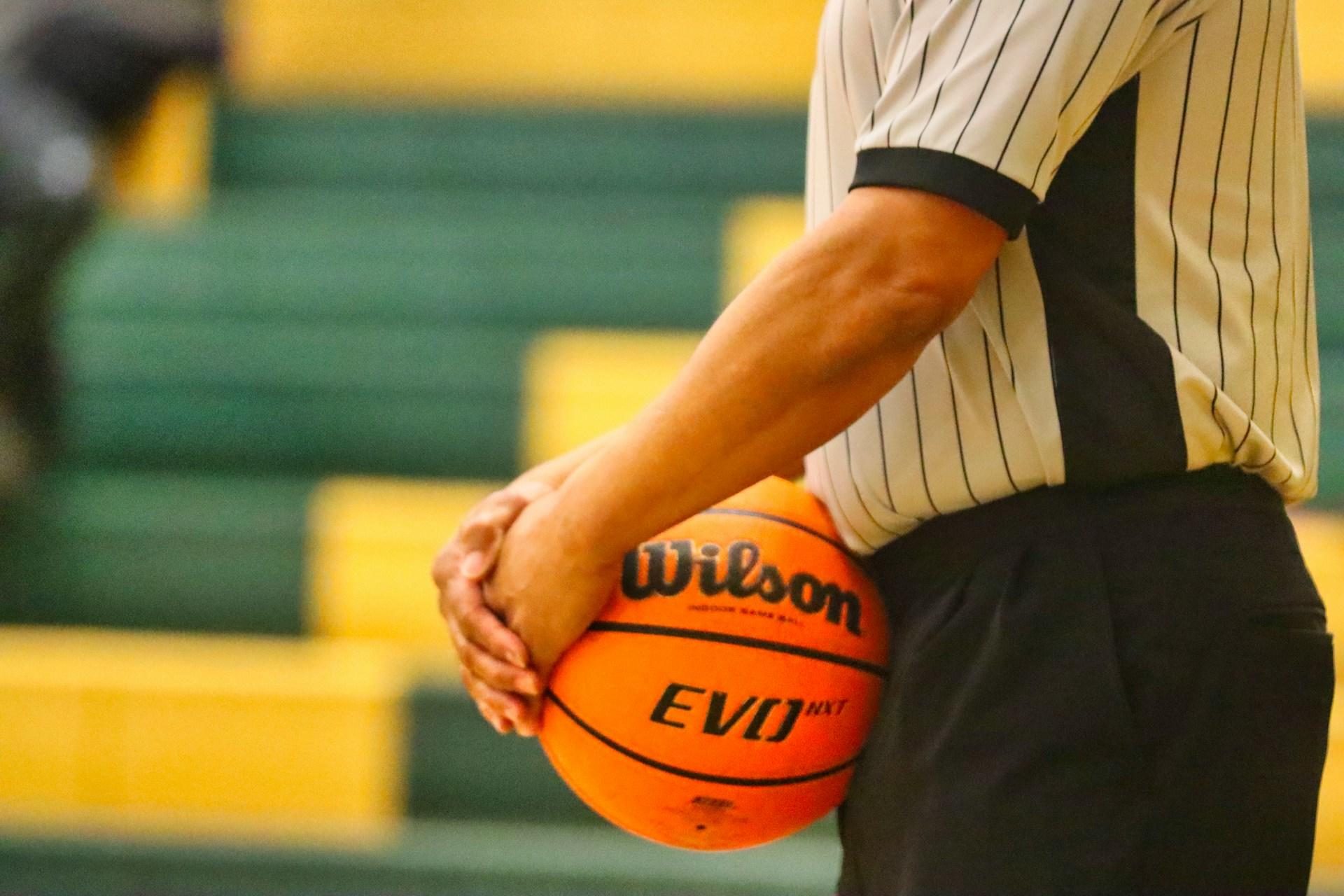 Referee holding a basketball.