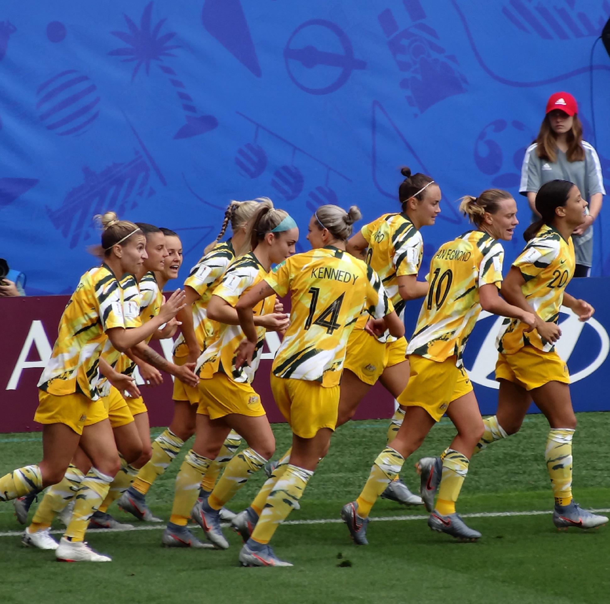 An athletic team wearing yellow uniforms on a football pitch.