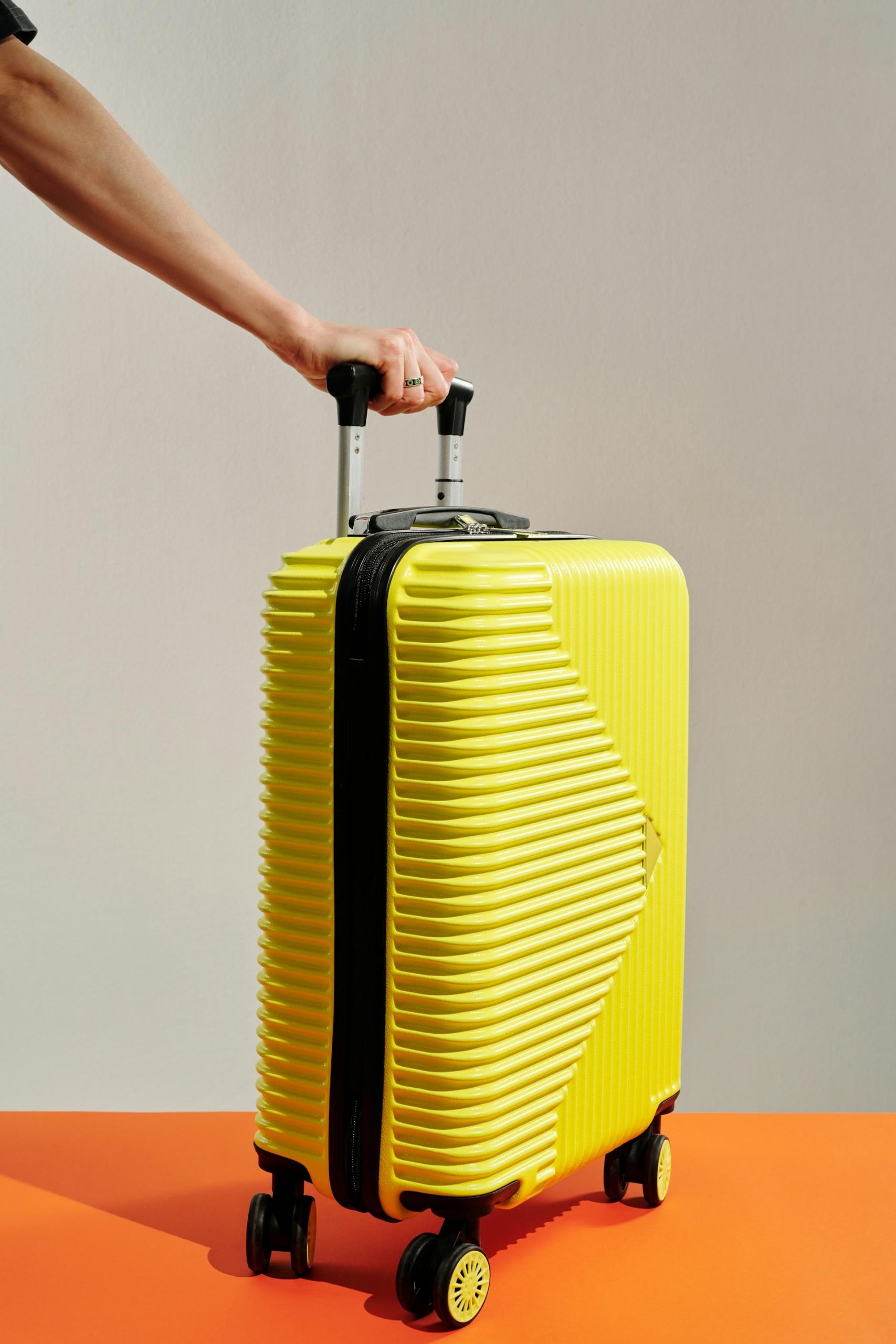 A yellow suitcase with black trim and wheels. 