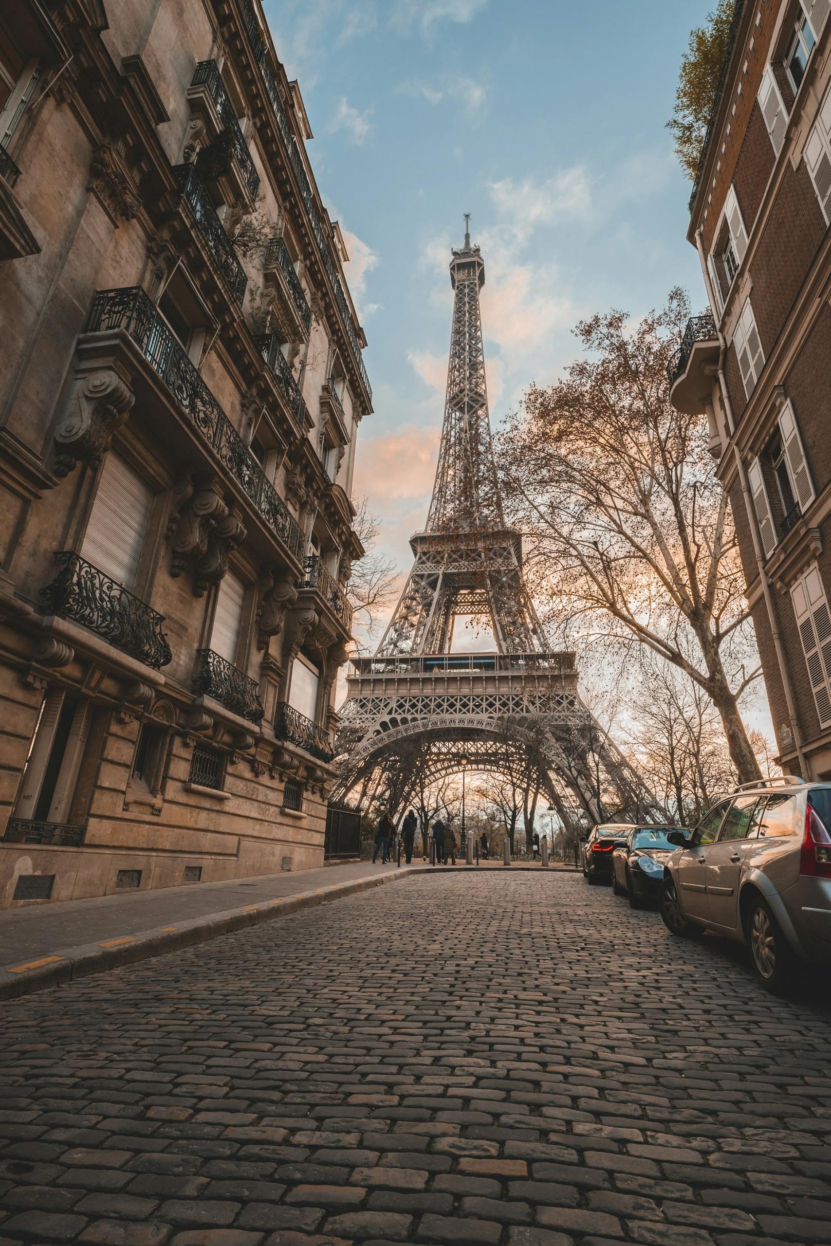 The Eiffel Tower at the end of an up-sloping cobblestoned road. 