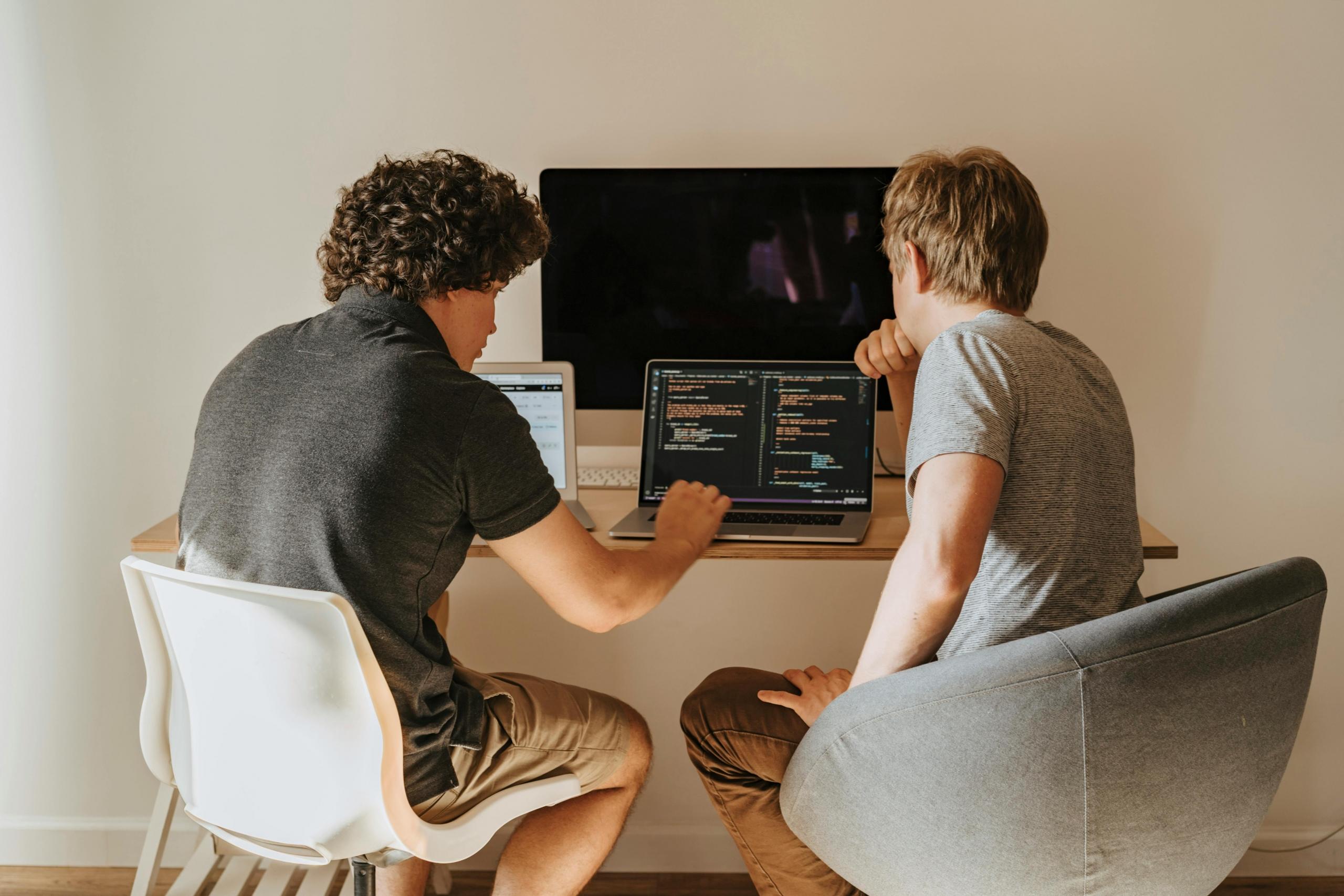 Two people looking at the screen of the computer