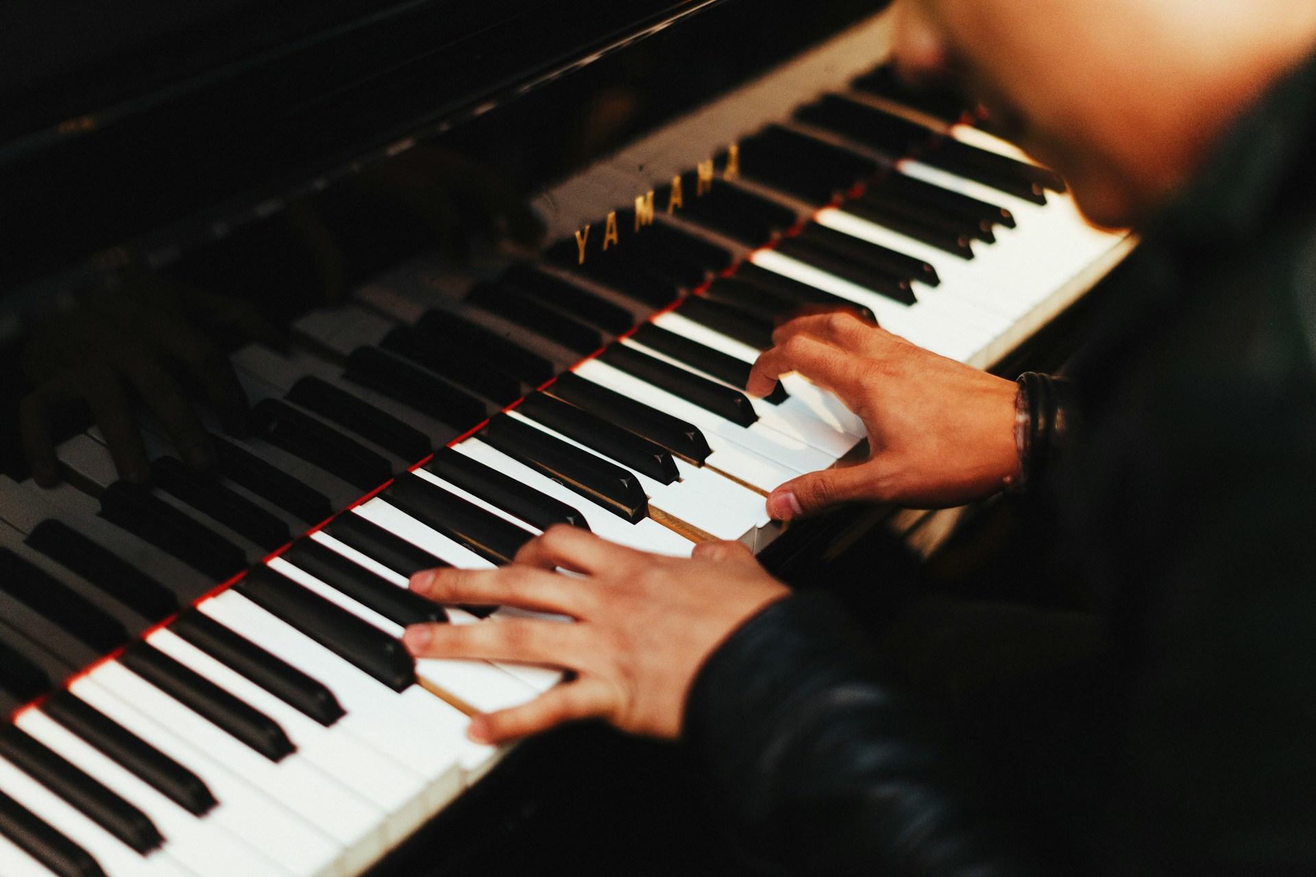 A pianist playing a Yamaha piano.