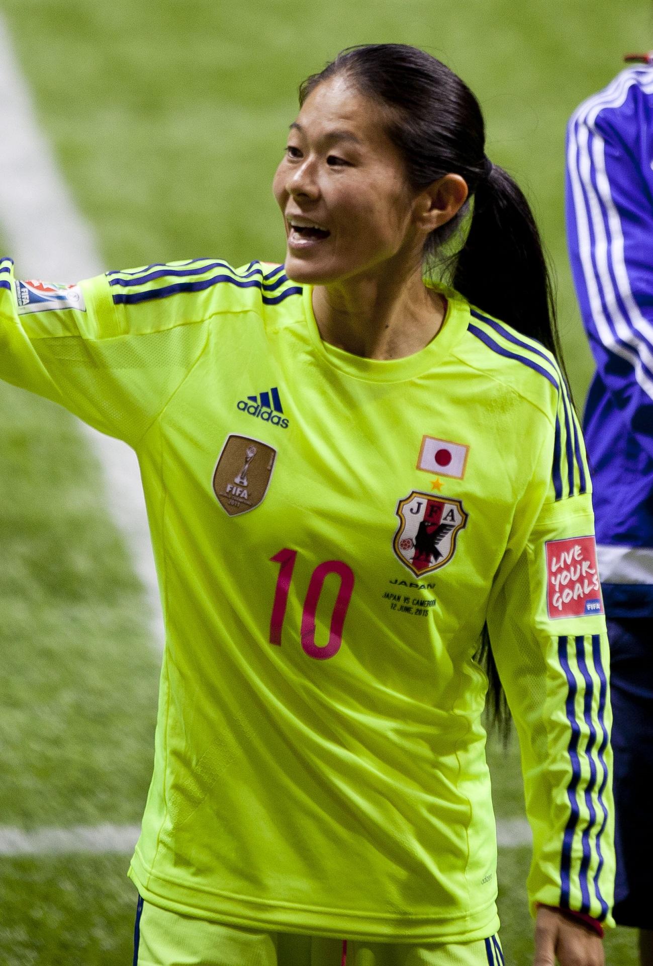 A person in a neon green jersey waves.