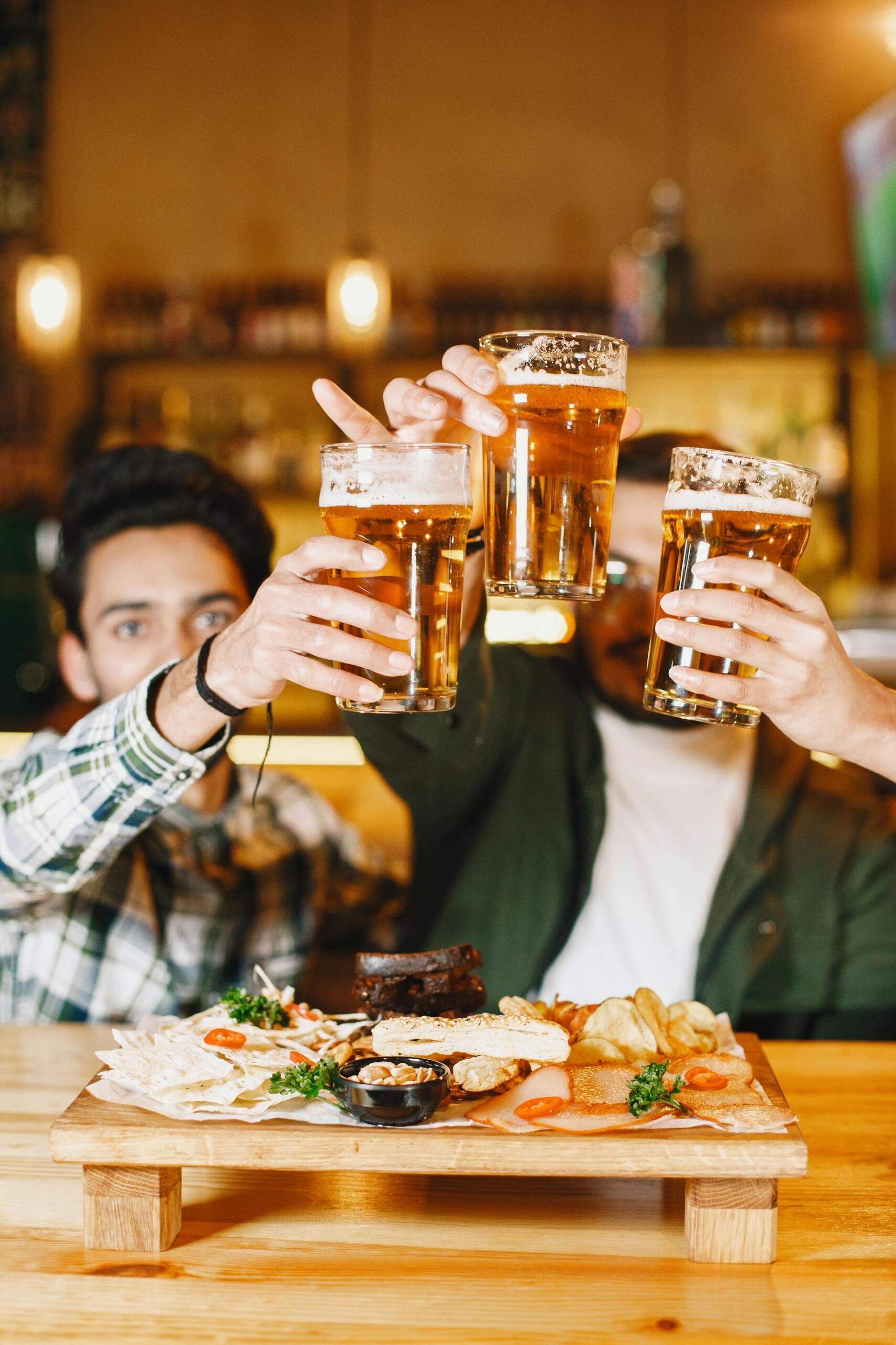 People Holding Beer Glasses at a Party.