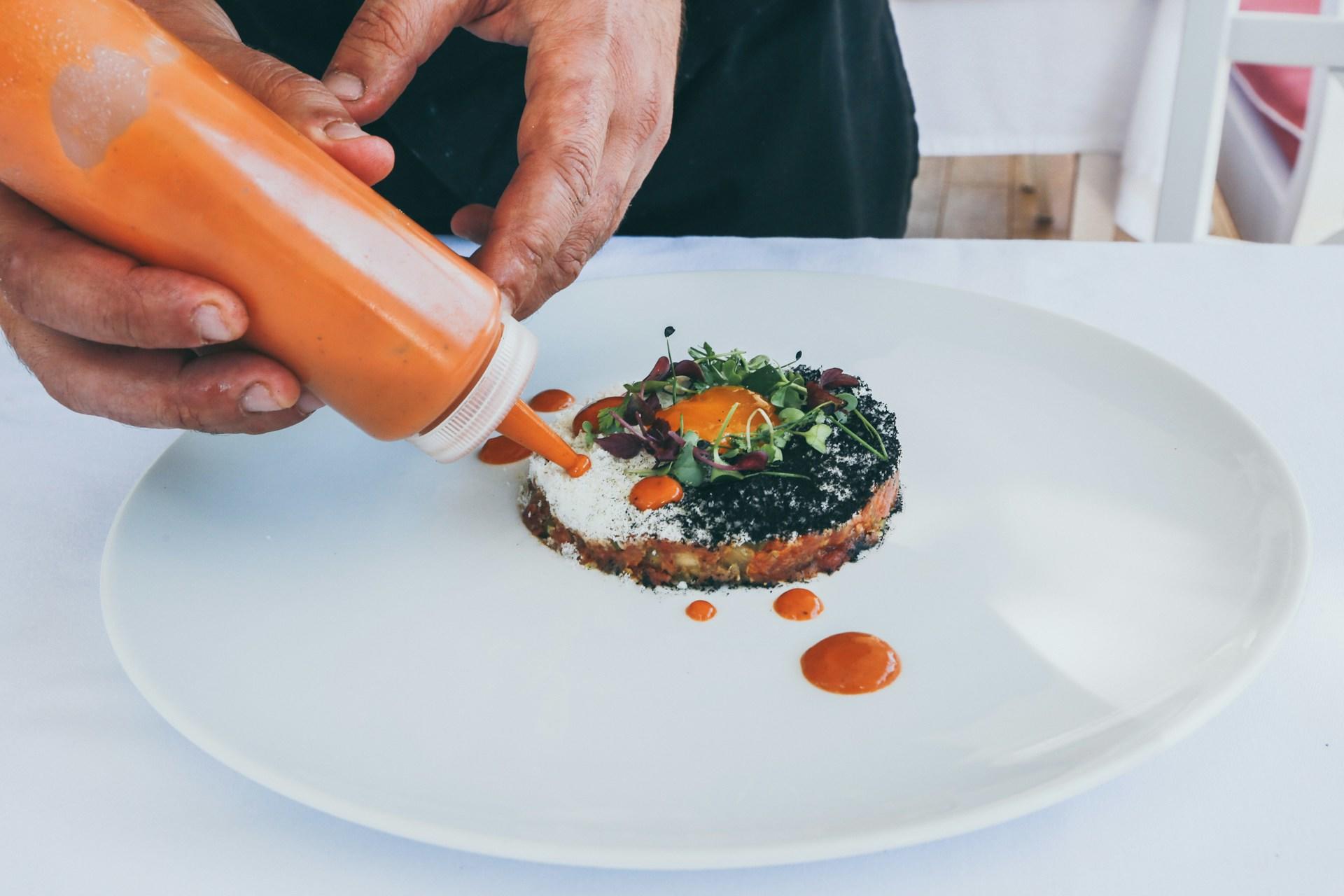 person preparing a gourmet food plate