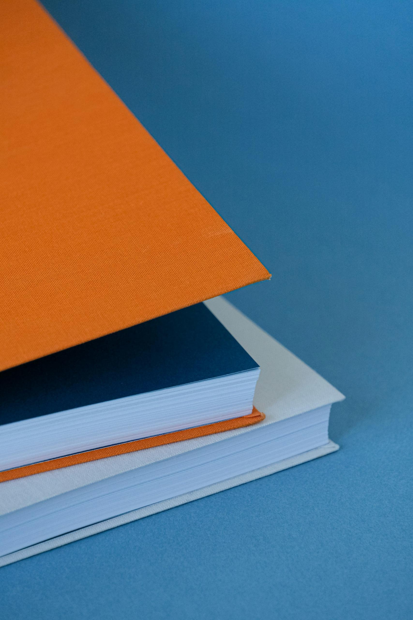 two books stacked on a blue surface. 