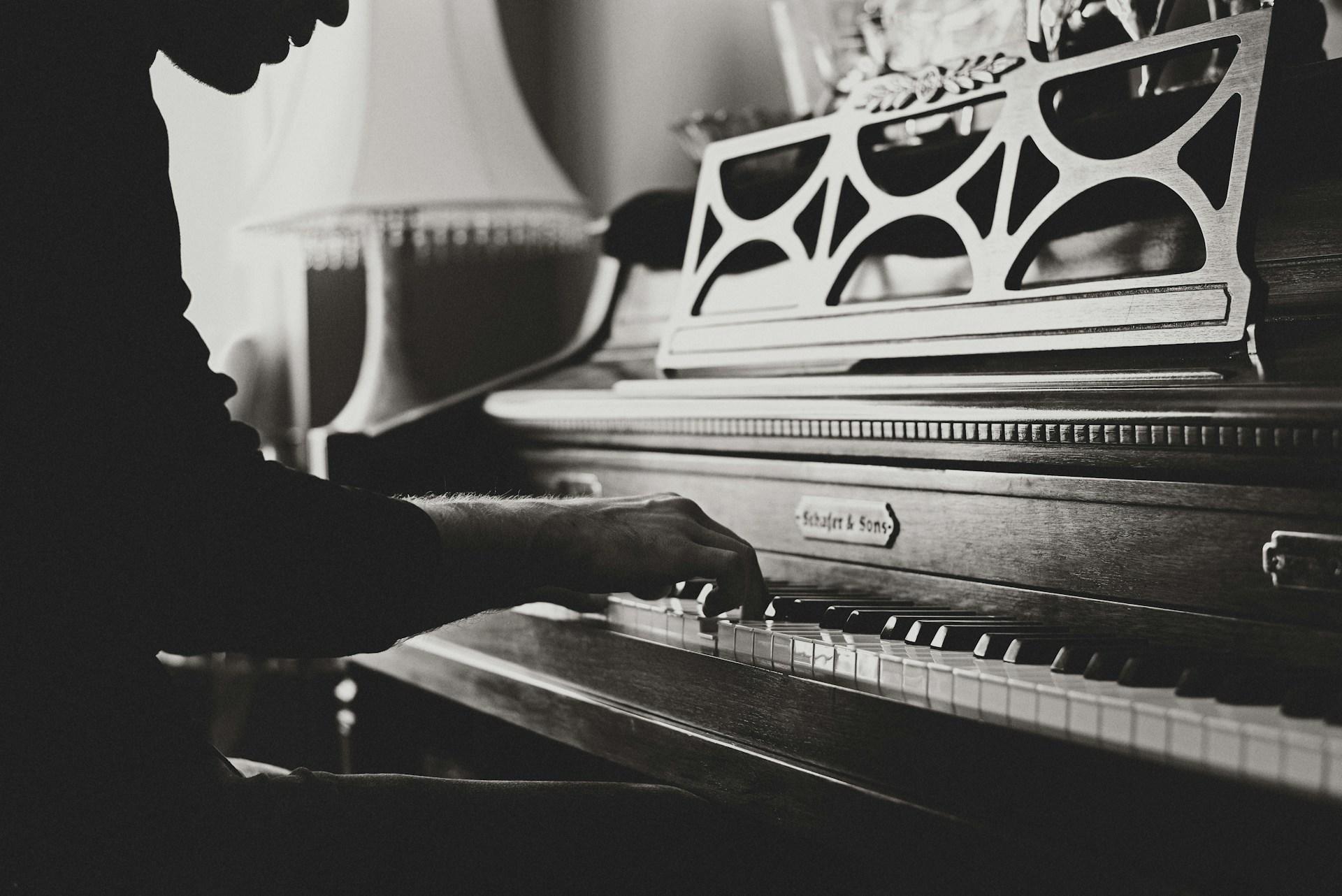person playing the piano in black and white
