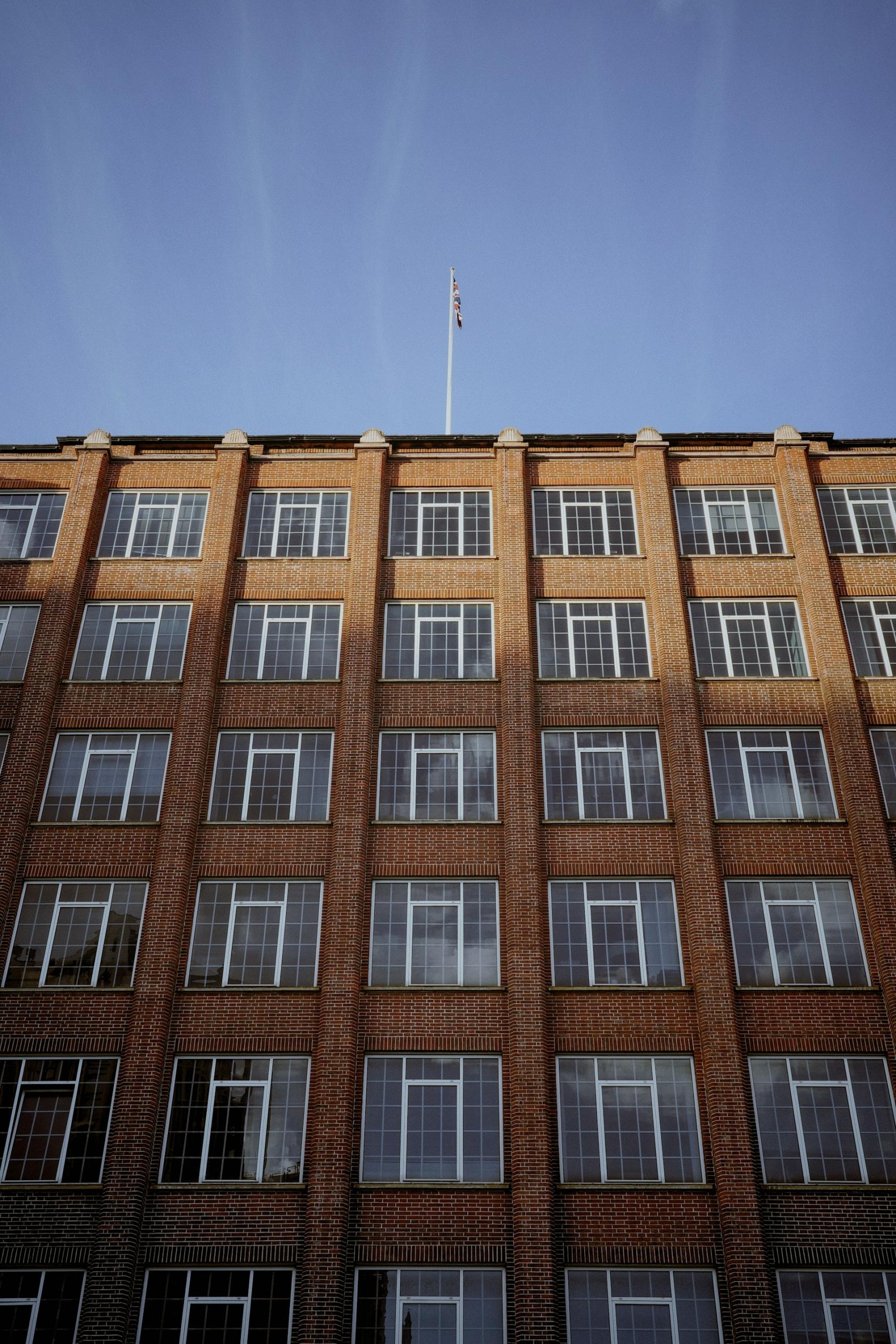A tall brick building with many windows on a sunny day.