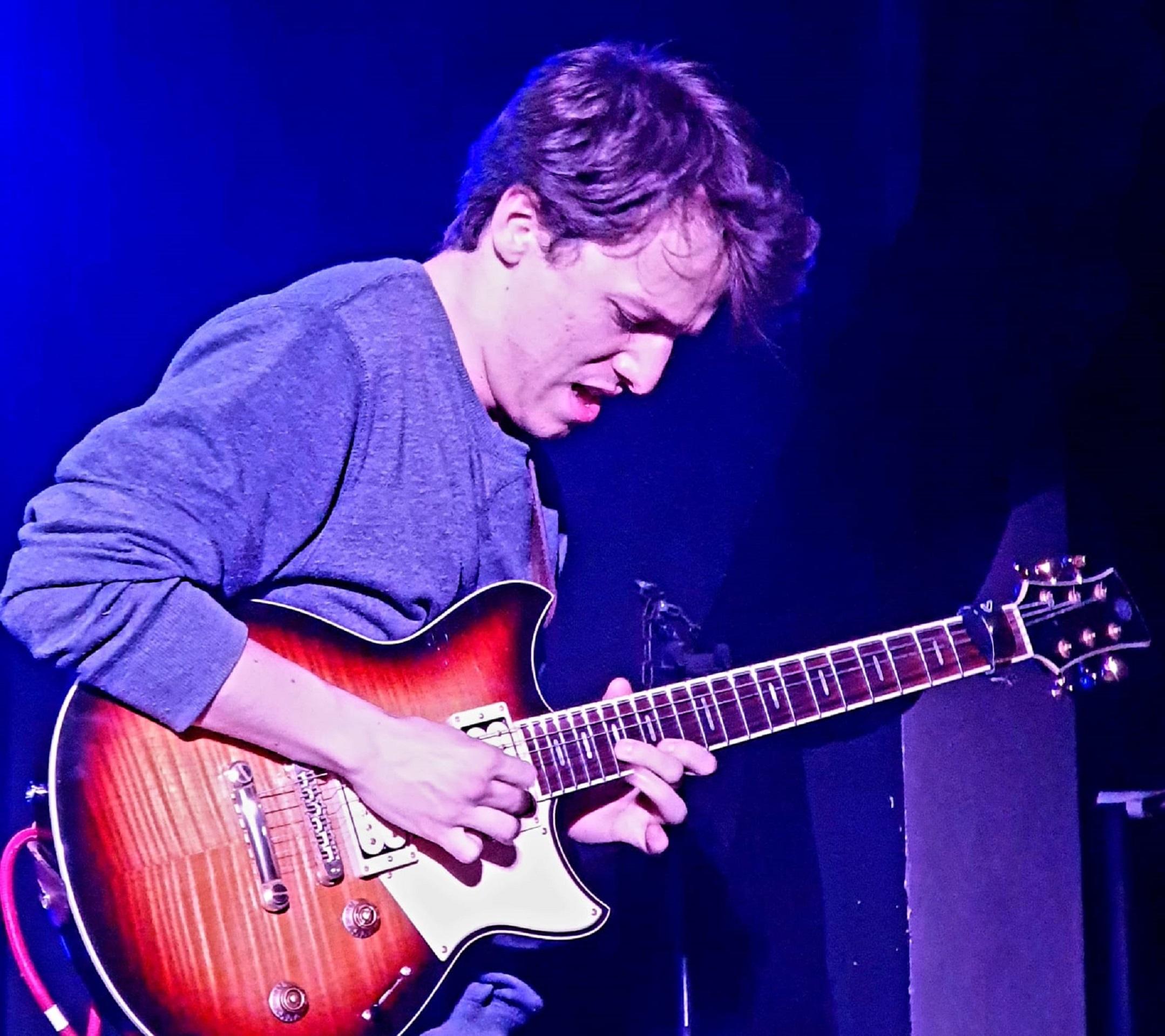 A man playing guitar on stage. 
