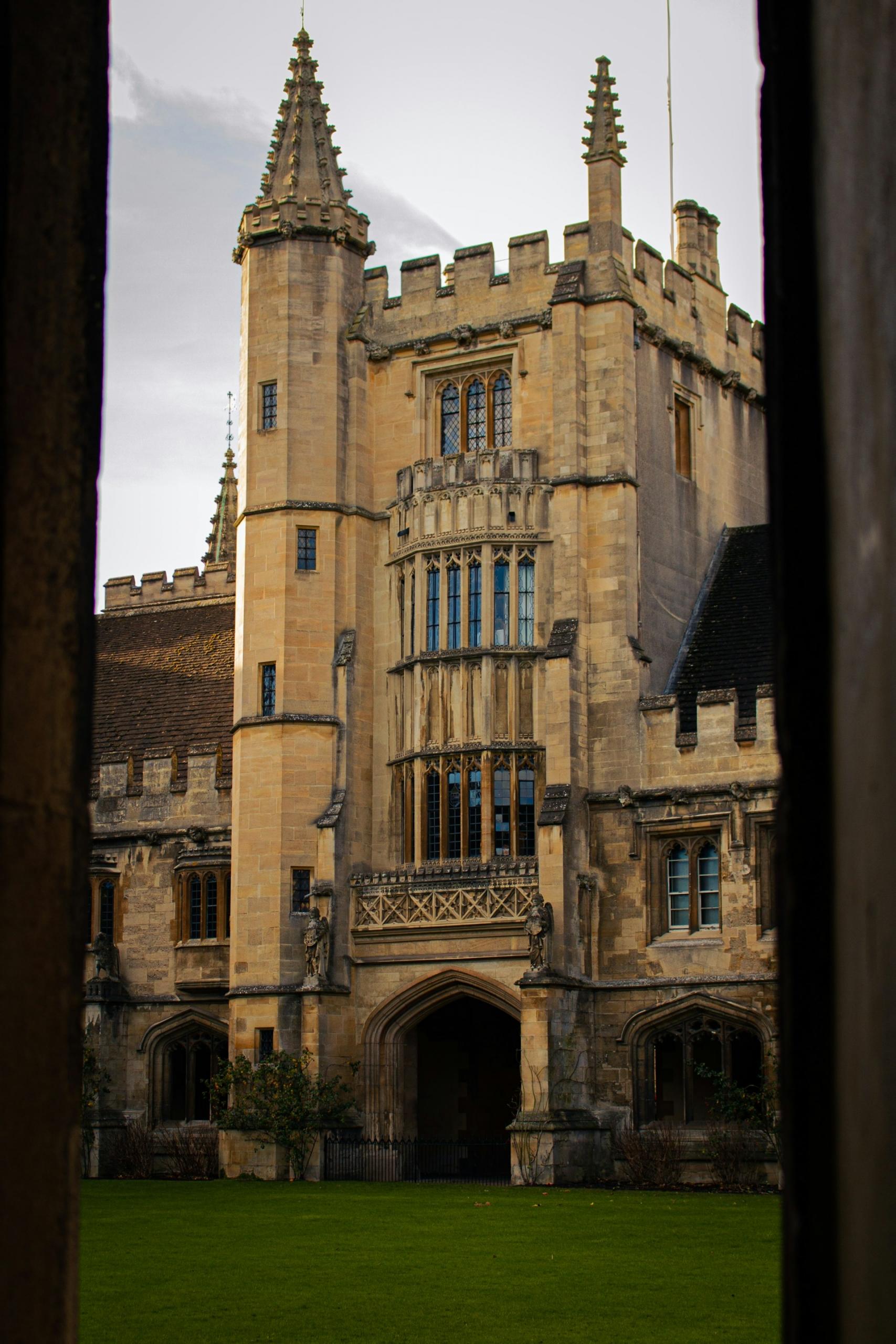 A stone building with a door opening on a green lawn. 