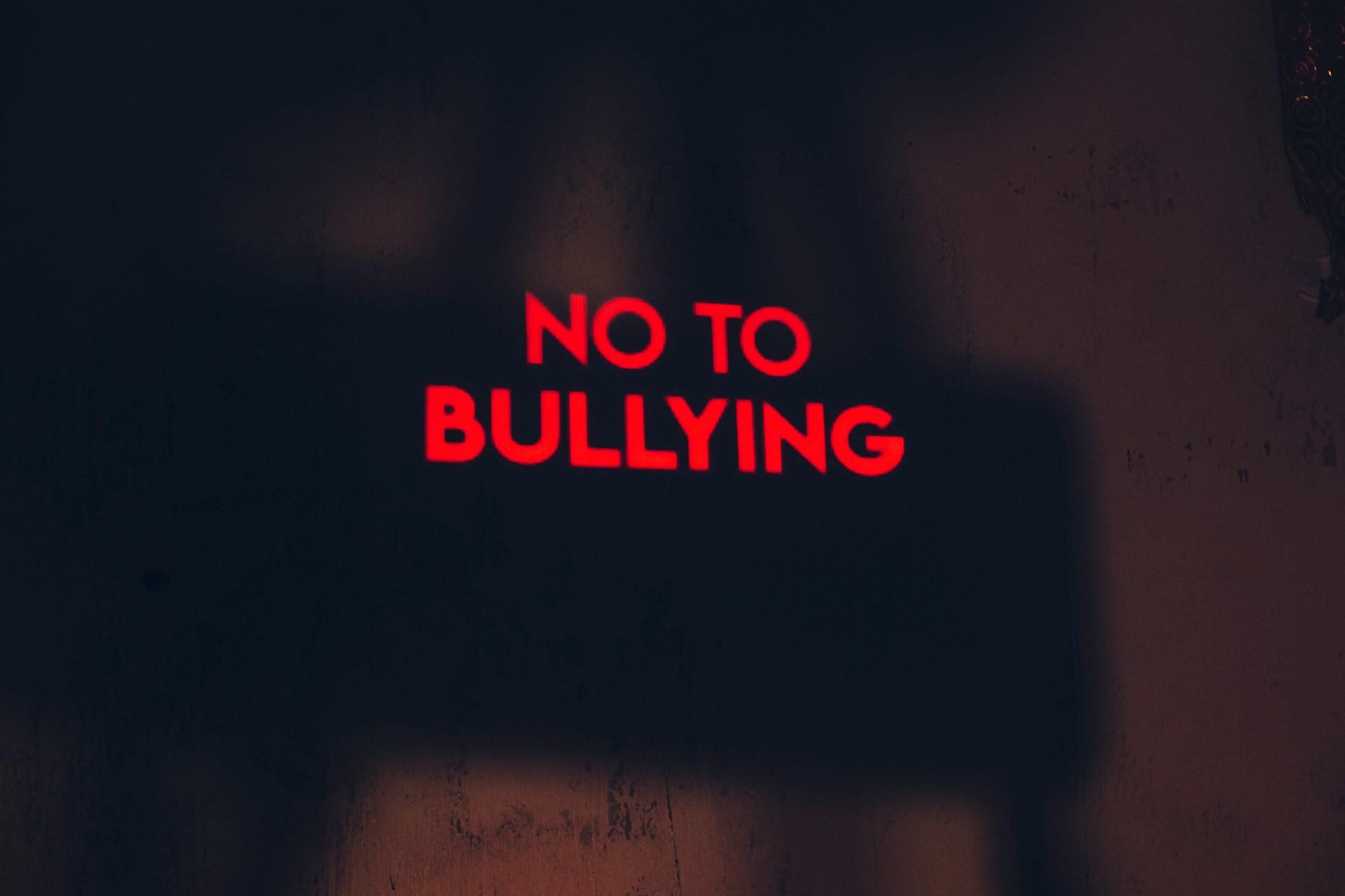 No to bullying sign illuminated in red letters.