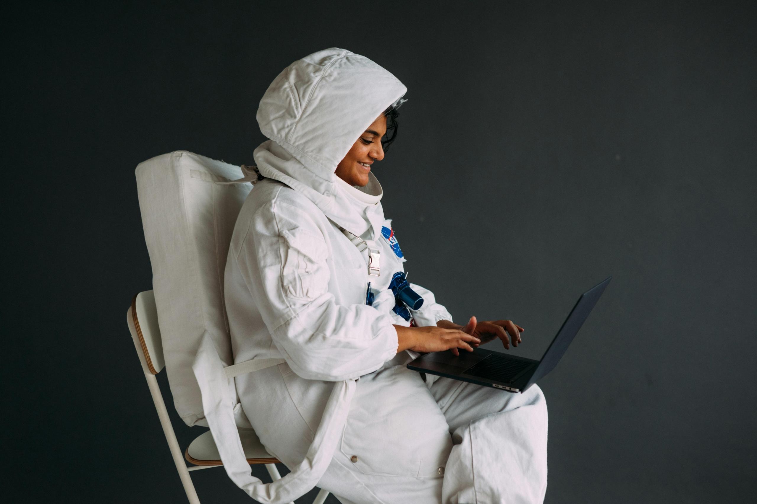 A female astronaut working on her laptop from space