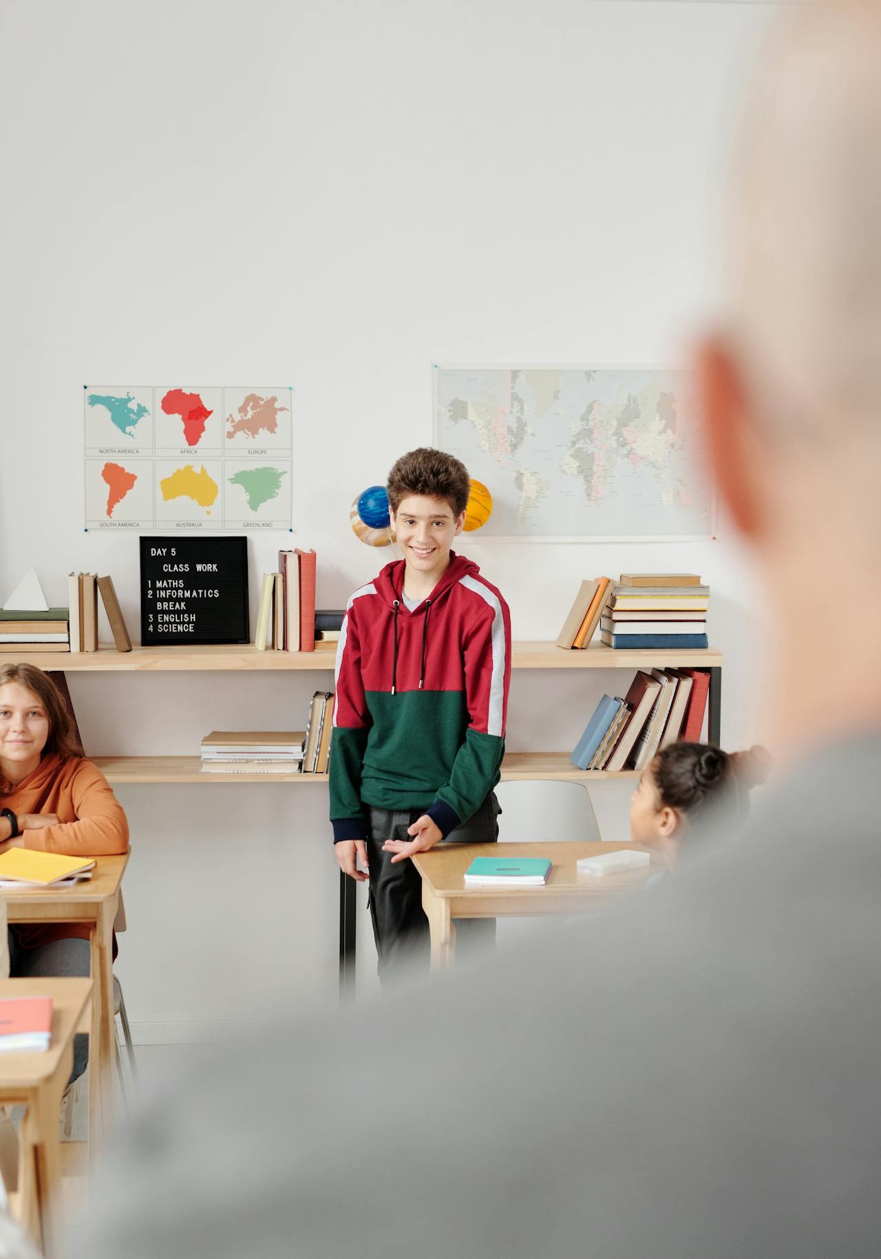 teacher and student standing up in a classroom.