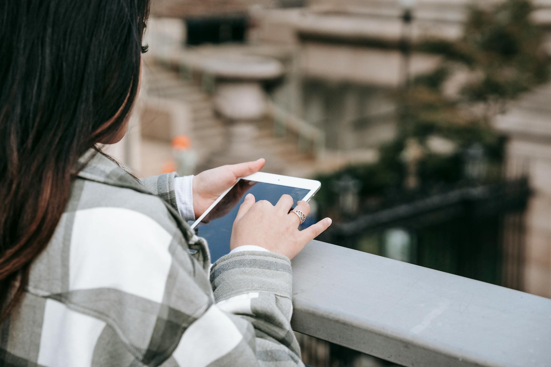 A woman looks at an iPad and scrolls through material.