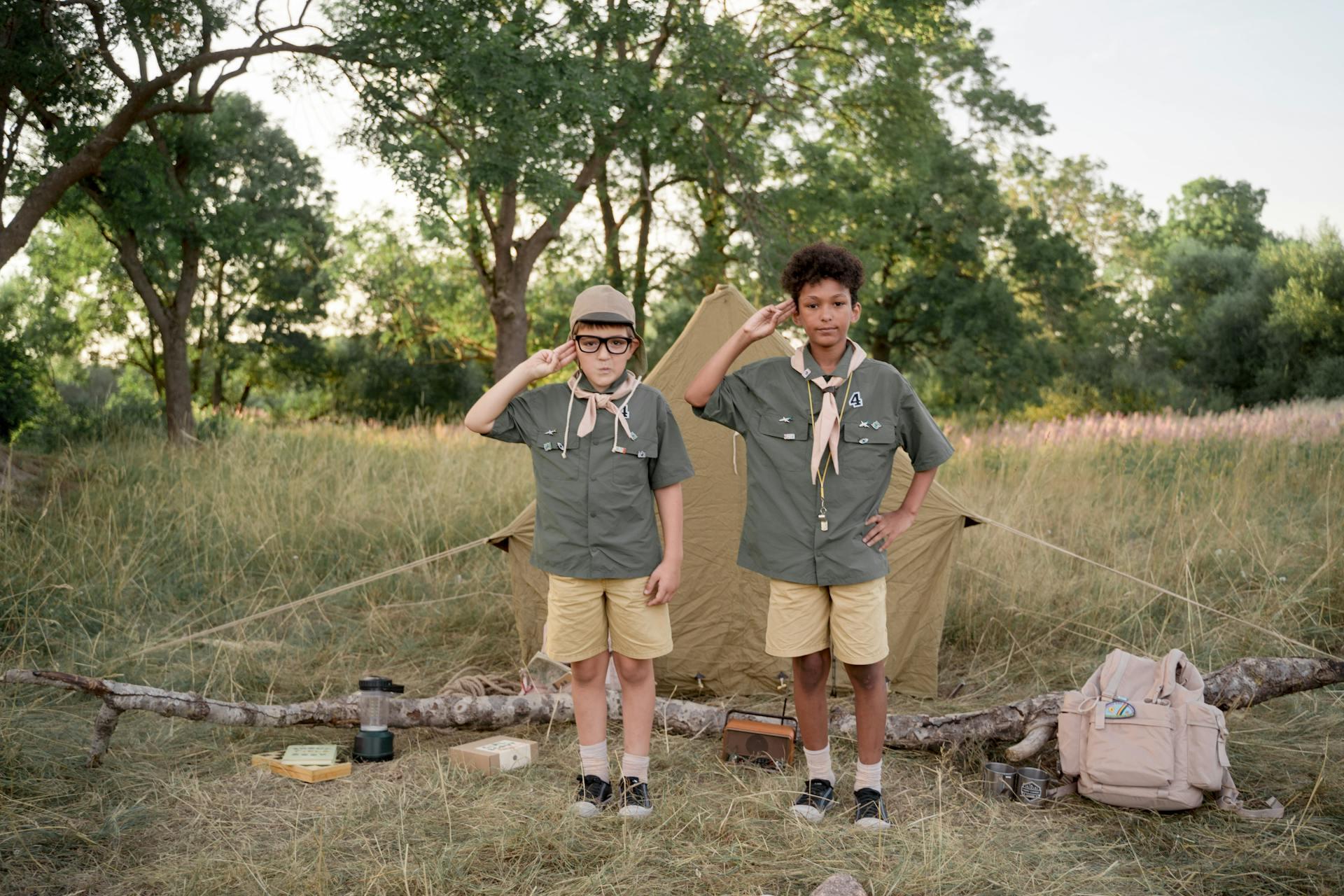 Two young scouts while on a hike salute the camera.