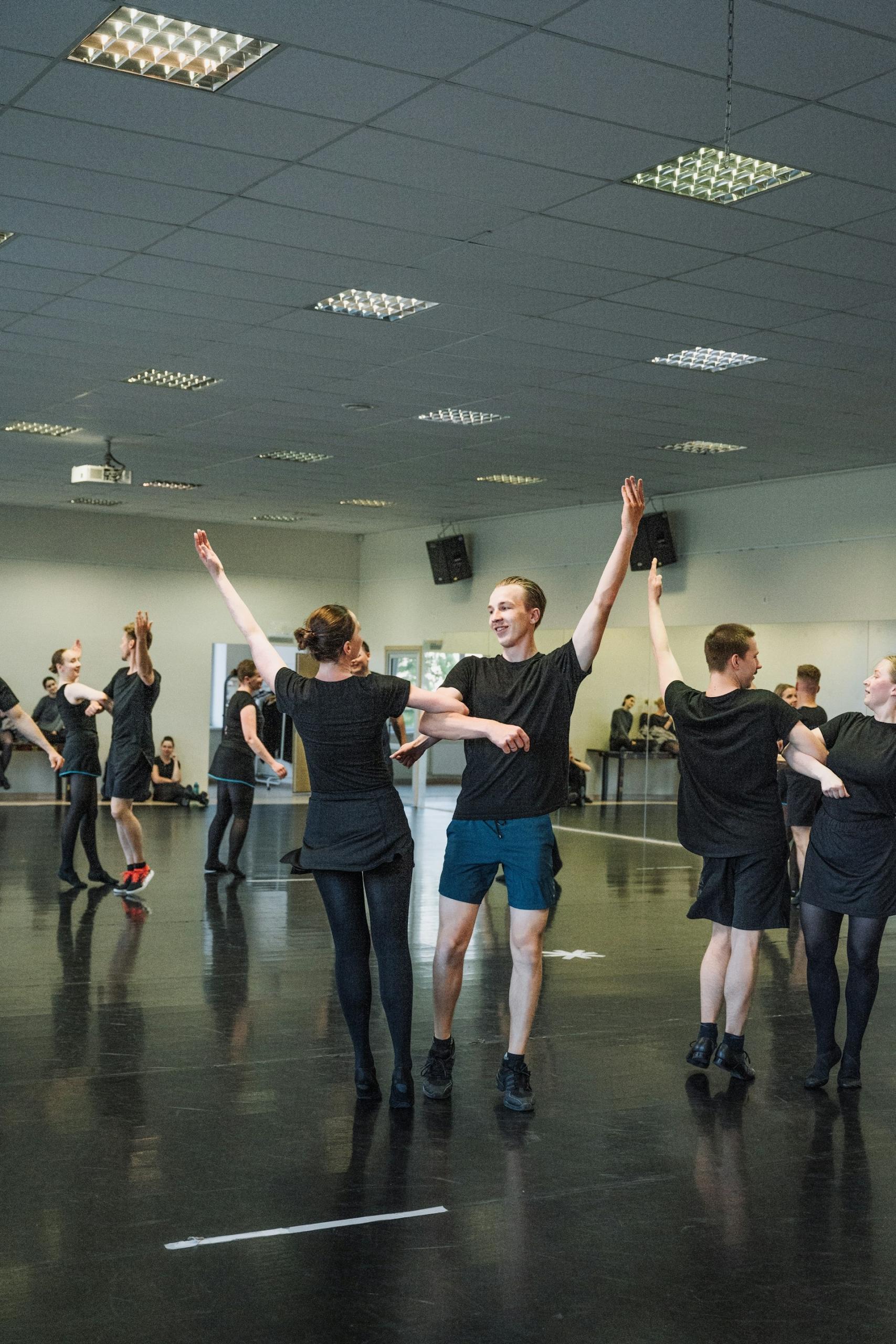 A group of people dance in a studio.