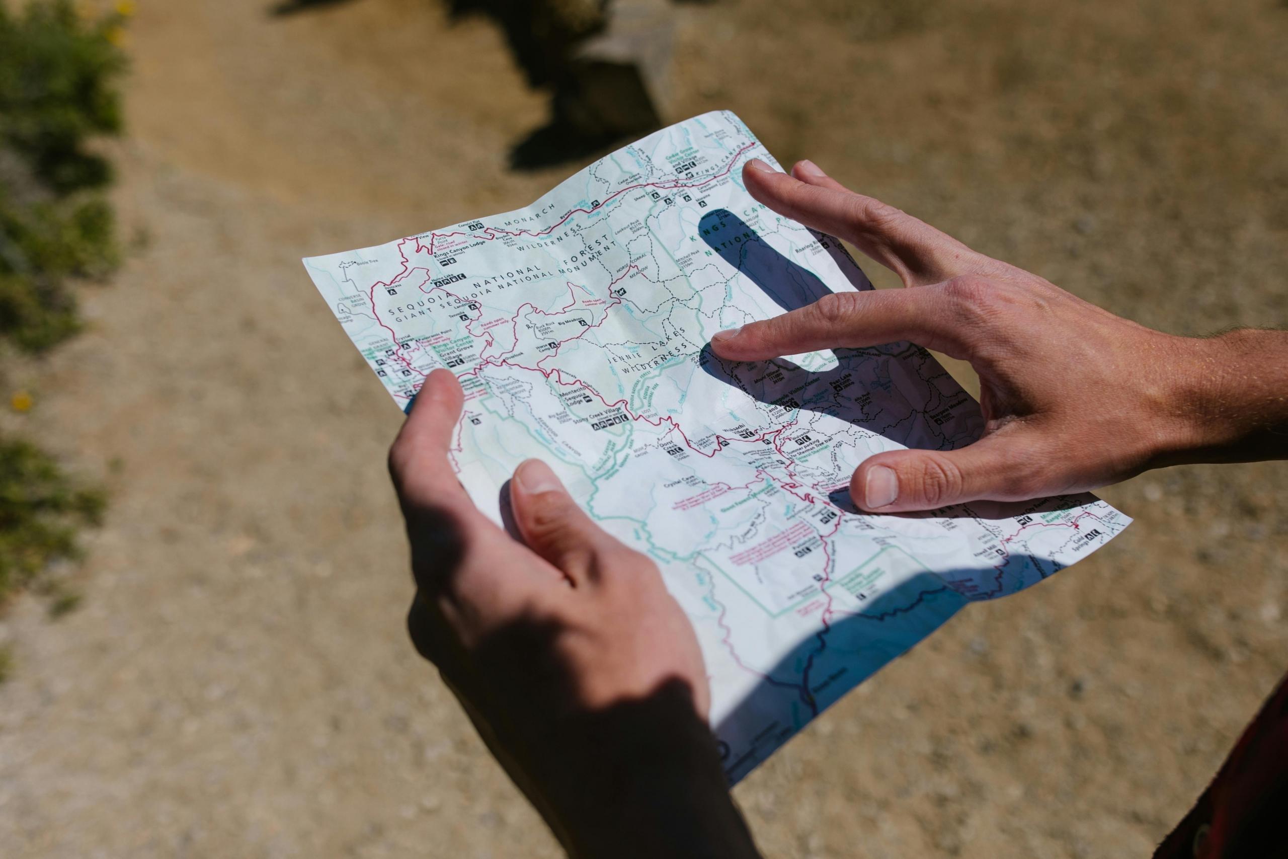 A map is being used by a man looking to find his way to his desired destination.