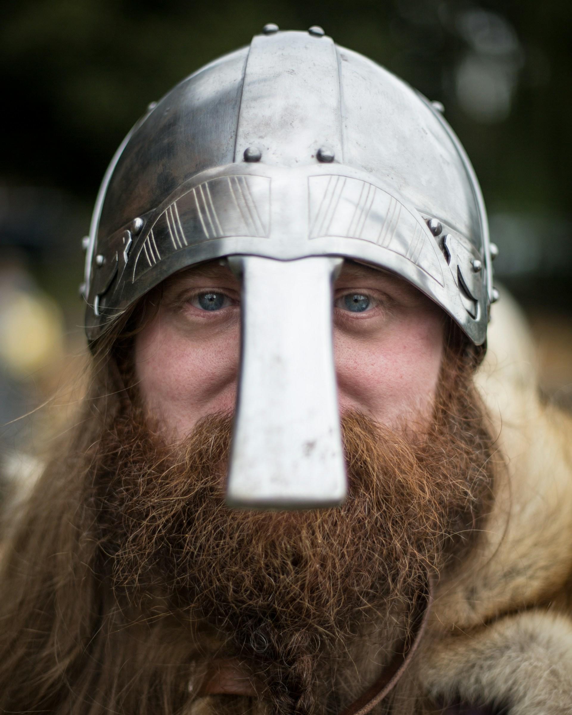 A bearded man wears a silver cask with nose plate. 