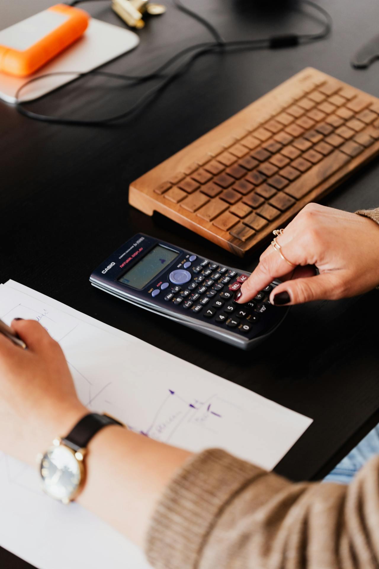 An accountant works on figures using a calculator.