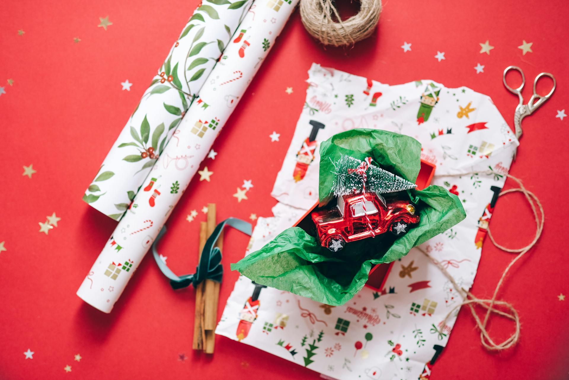 A toy car wrapped in homemade wrapping paper and Christmas craft materials