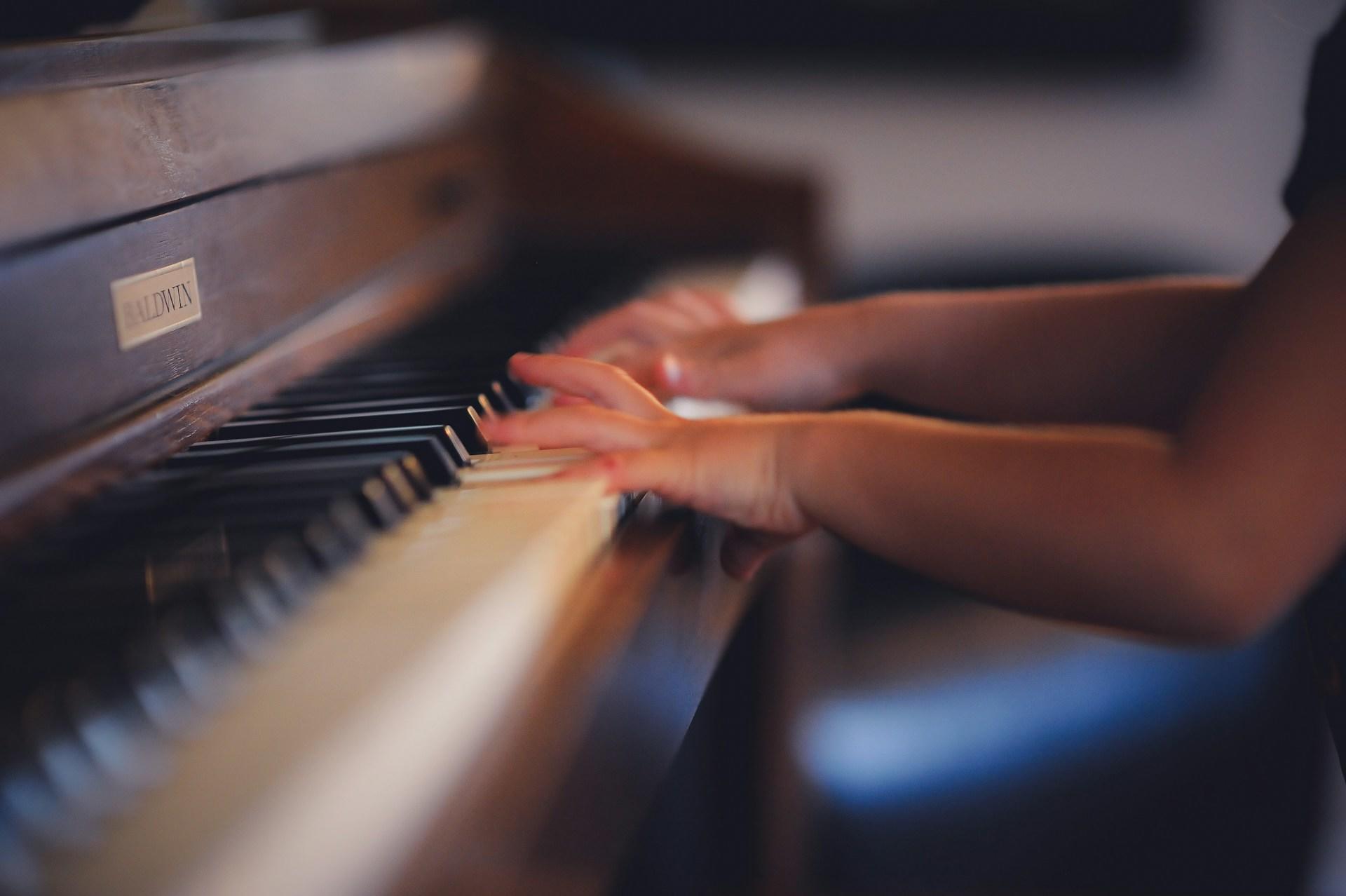 A person playing a Baldwin piano.