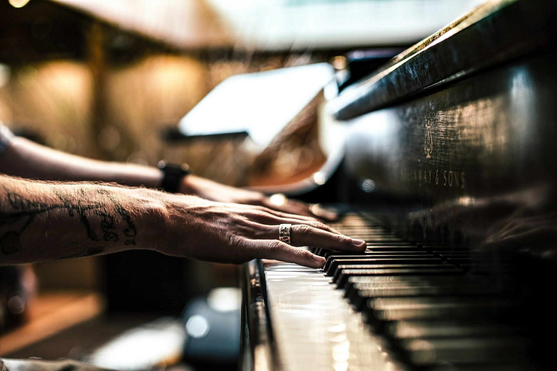 A closeup of a pianist's hands playing a Steinway piano.