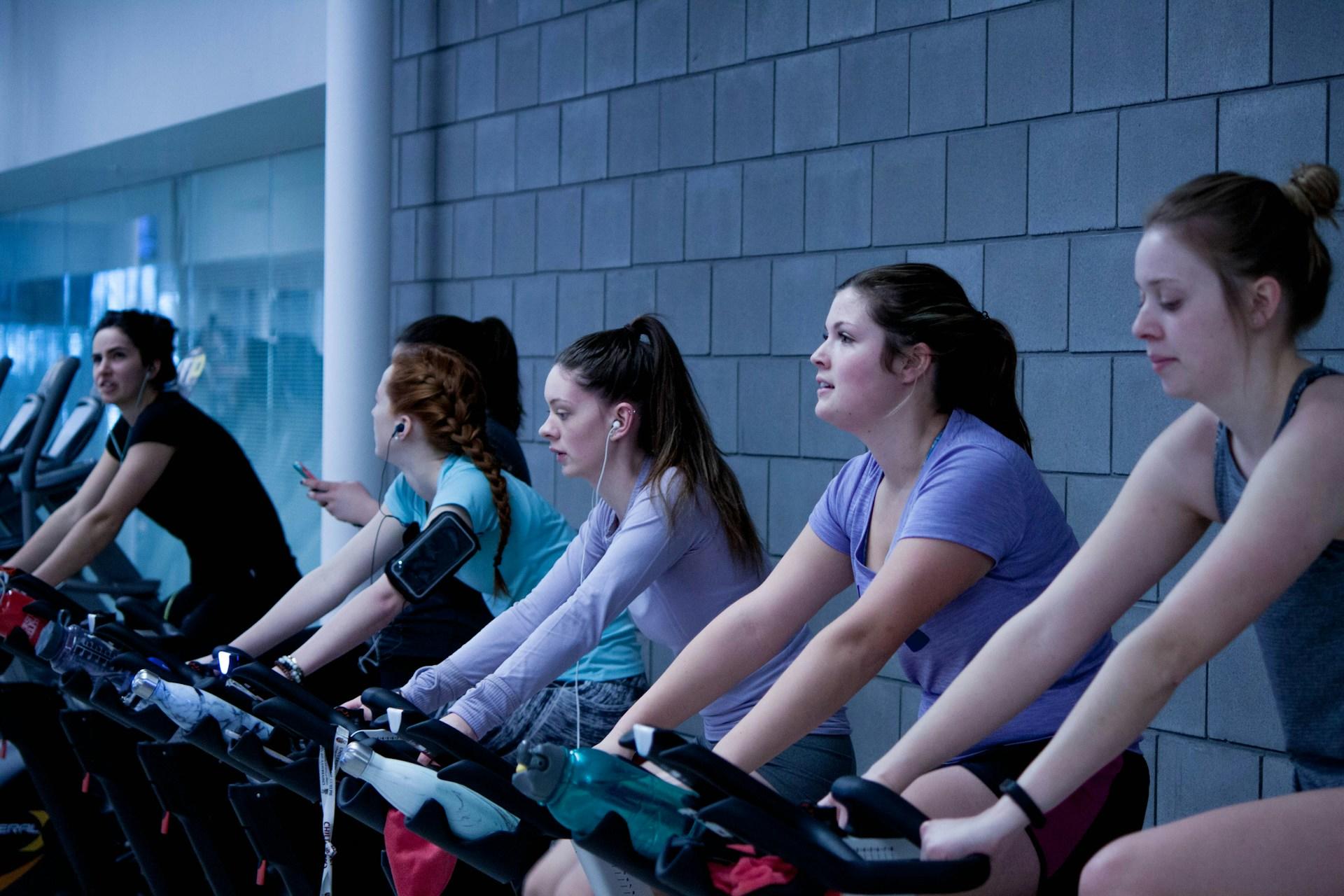 Four women riding stationary bikes.